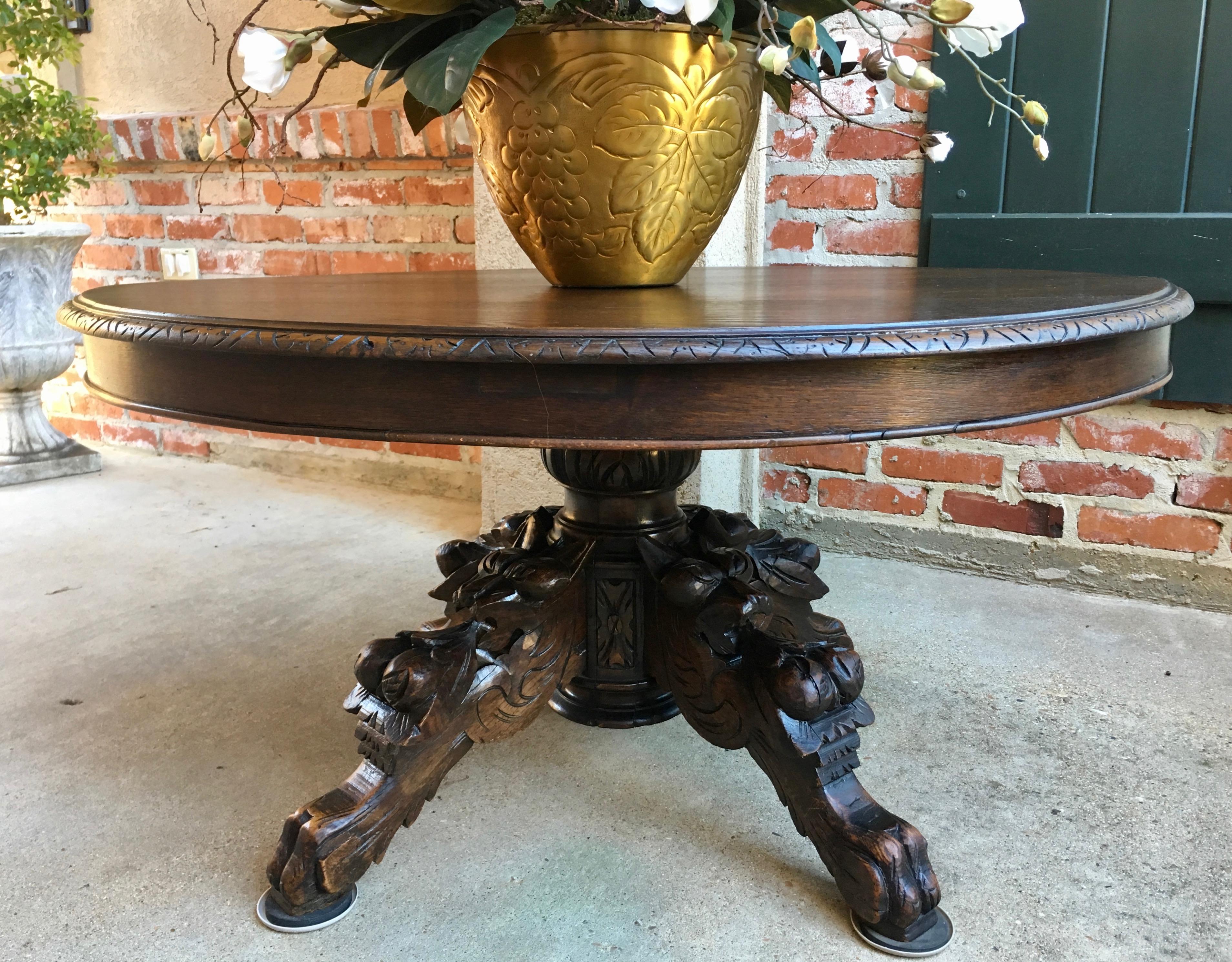 Direct from France, a stunning antique French carved Black Forest oval coffee table!
~Massive carved pedestal base supported by ornate hand carved dimensional griffins on all four legs with Black Forest details~
~Solid oak, the oval table top is