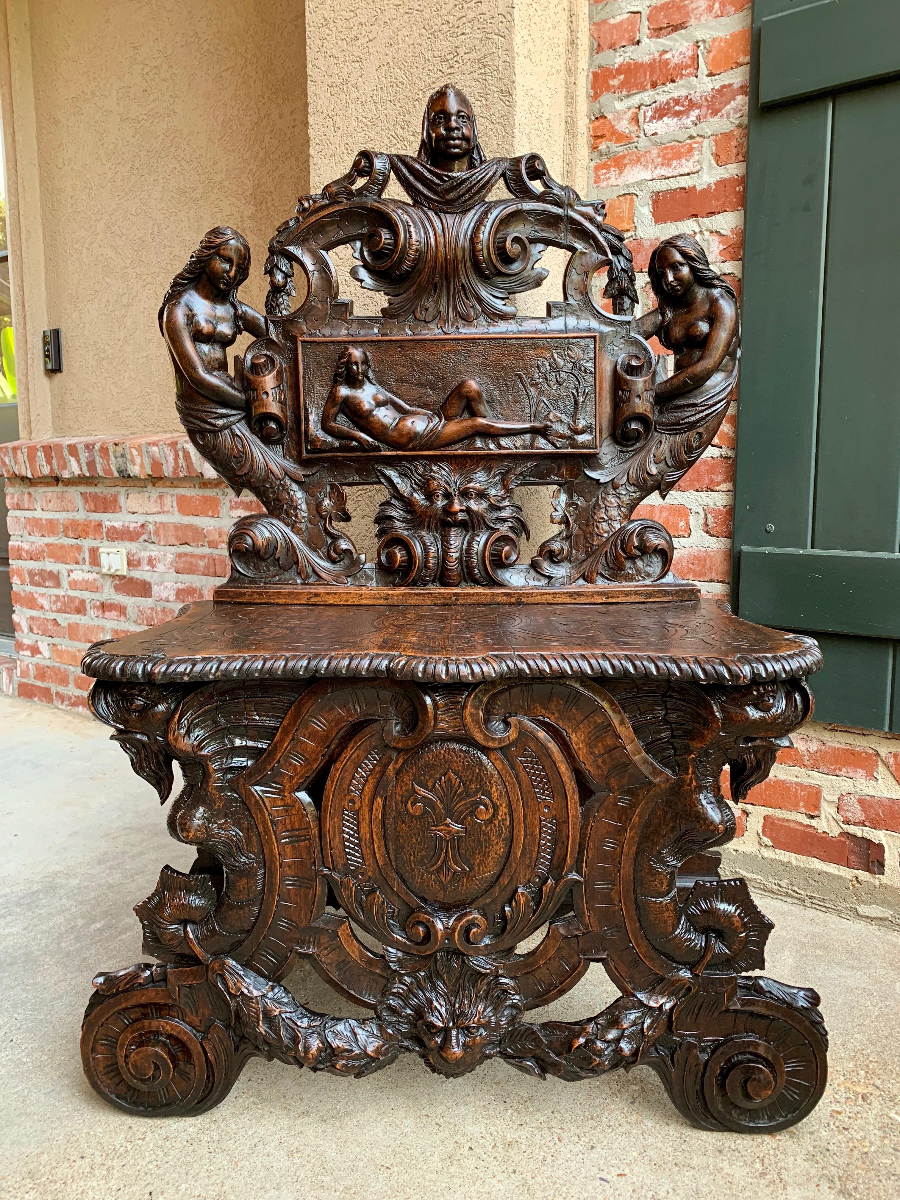 Direct from France, highly ornate antique French carved oak renaissance hall bench or loveseat with exquisite hand carved details!
Upper crown has two full length mermaids holding the scroll/plaque that features a full length female figure in