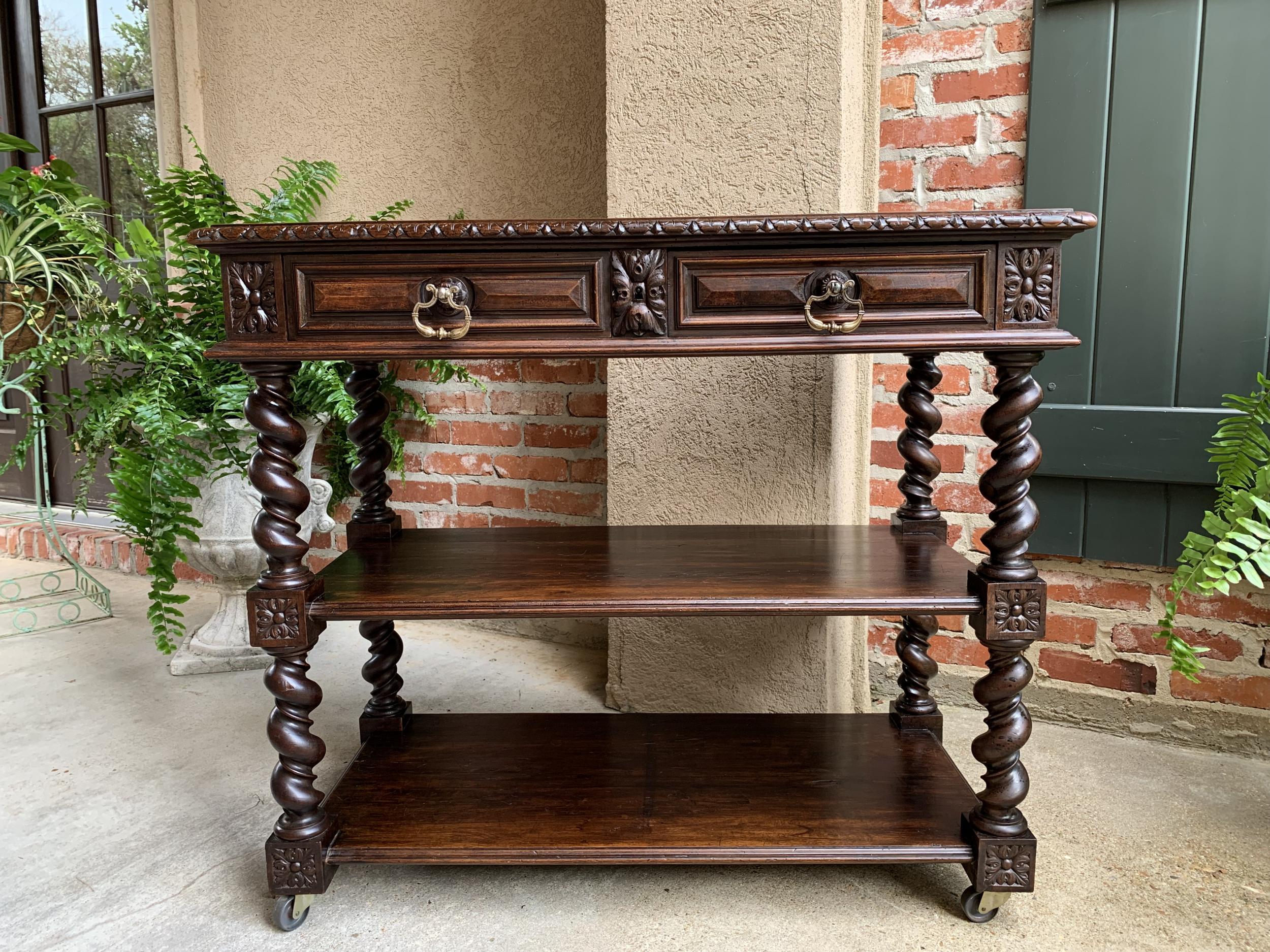 Antique French carved oak server sideboard rolling cart table barley twist shelf

~Direct from France~
~Lovely antique French server, versatile as a sideboard, hall table, bookshelf or wine cart~
~Beveled edge top above the frieze that features two