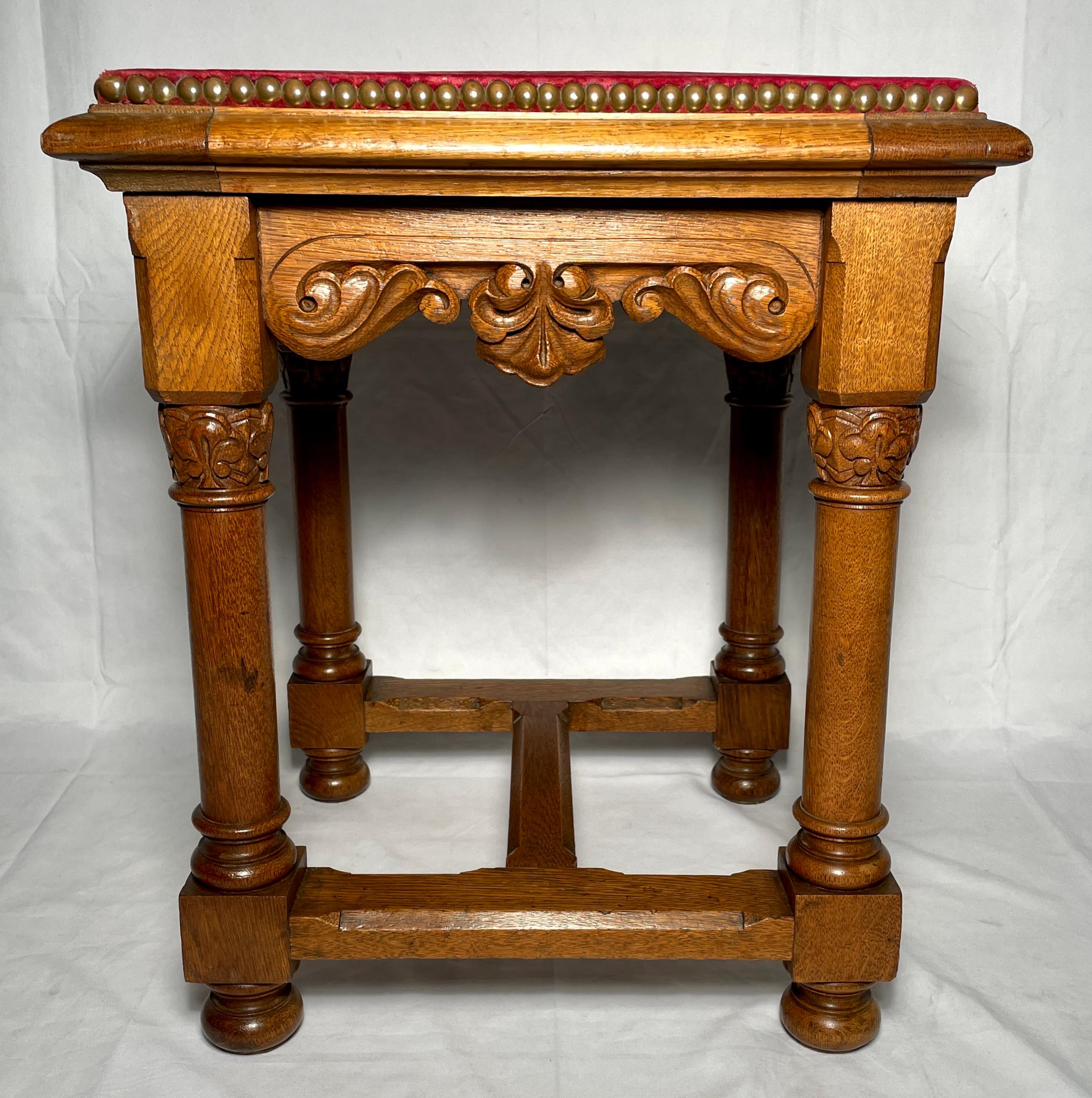 Antique French carved oak stool with red velvet seat and grommet detailing, circa 1900. There are 2 of these available. 