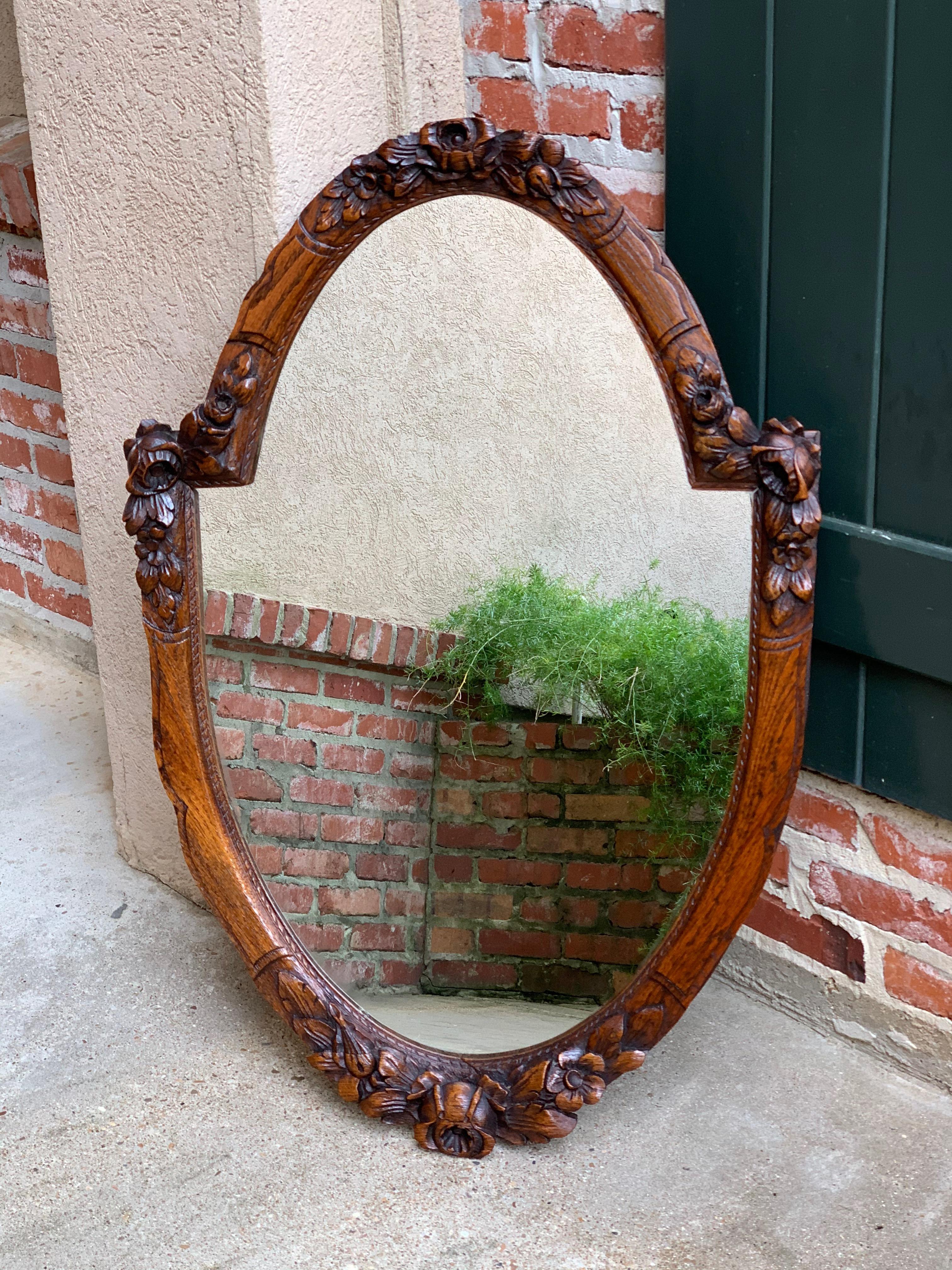 Direct from France, a fabulous (and quite large) antique French oak frame wall mirror with exquisite hand carved details~
~Upper crown has lovely dimensional carved floral bouquet. Carved wide band oval sides are stepped out and feature more of the