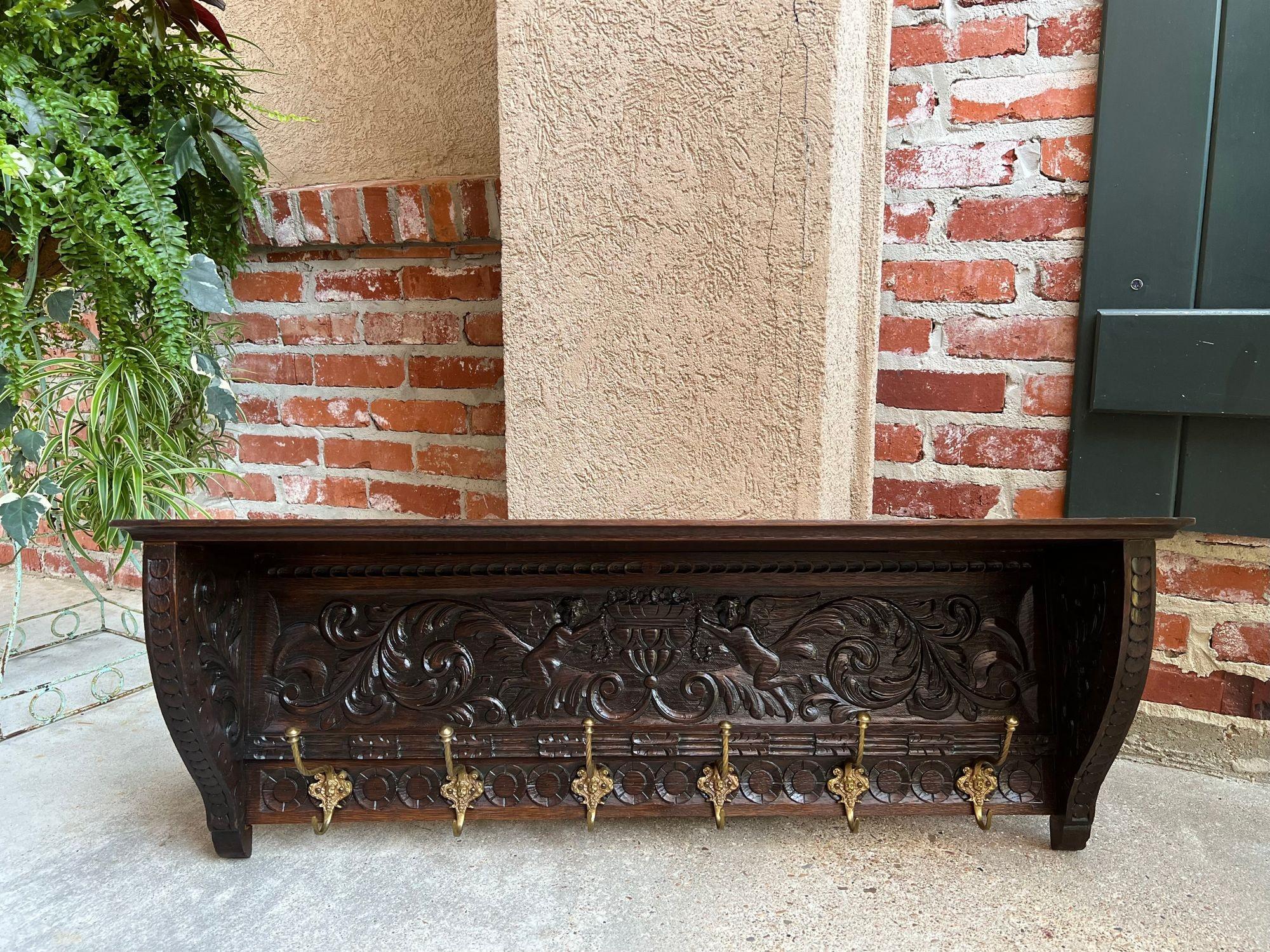 Antique French carved oak wall shelf coat hat rack farmhouse kitchen w brass hooks.
 
Direct from France, another lovely antique wall shelf, in a large, 41” length. Gorgeous Renaissance hand carvings throughout, with a center panel of cupids