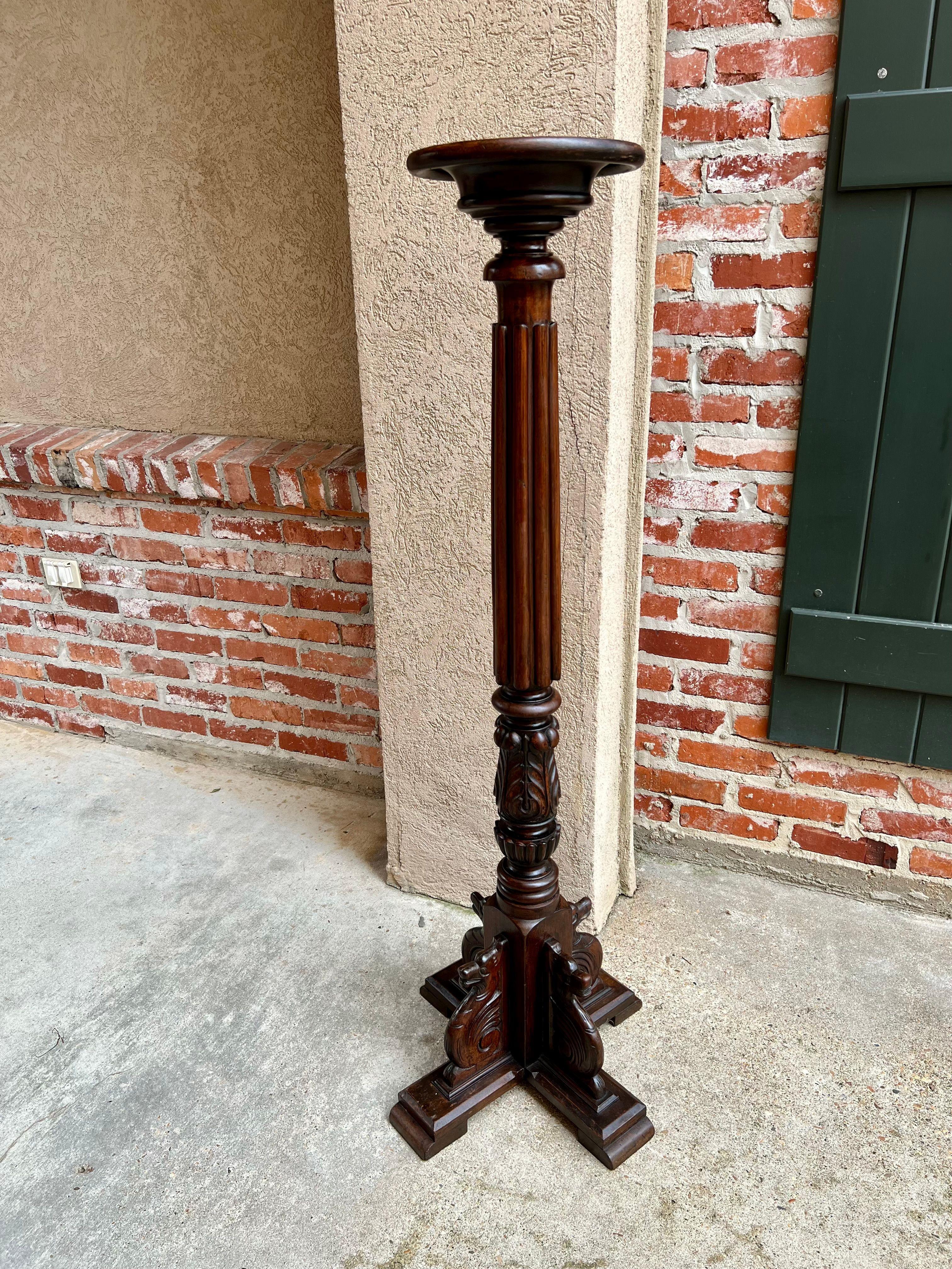 Antique French carved pedestal plant stand bronze column display renaissance.

Direct from France, a tall and well carved pedestal/plant stand.
Round disc top over a multiple level turned disc platform. Tall baluster has thick, reeded portion above