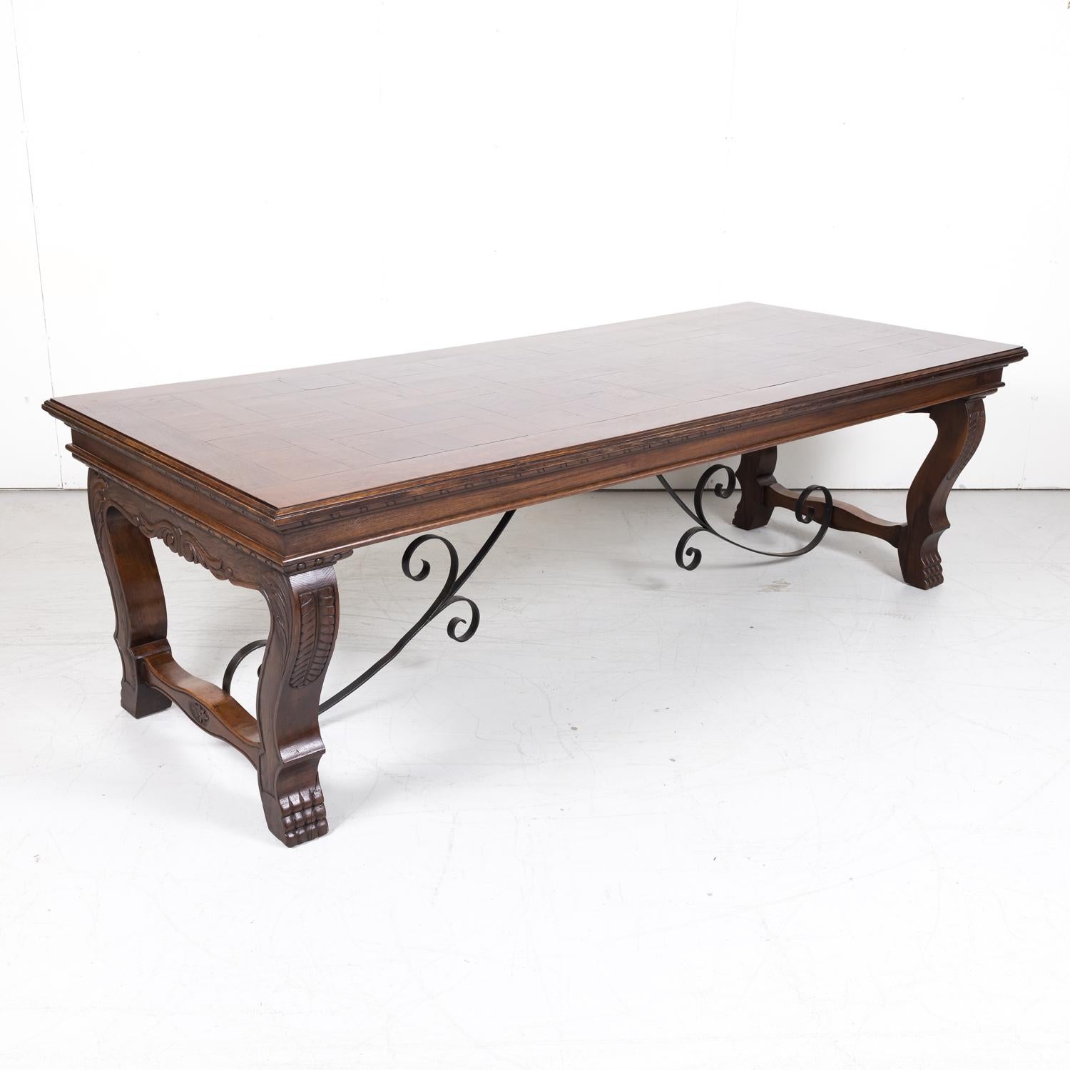 A carved French Renaissance style dining table handcrafted near Bordeaux of old growth French oak, circa 1920s. Having a rectangular parquet top with stepped gadrooned edge over a carved skirt, this antique French table with its rich, deep patina