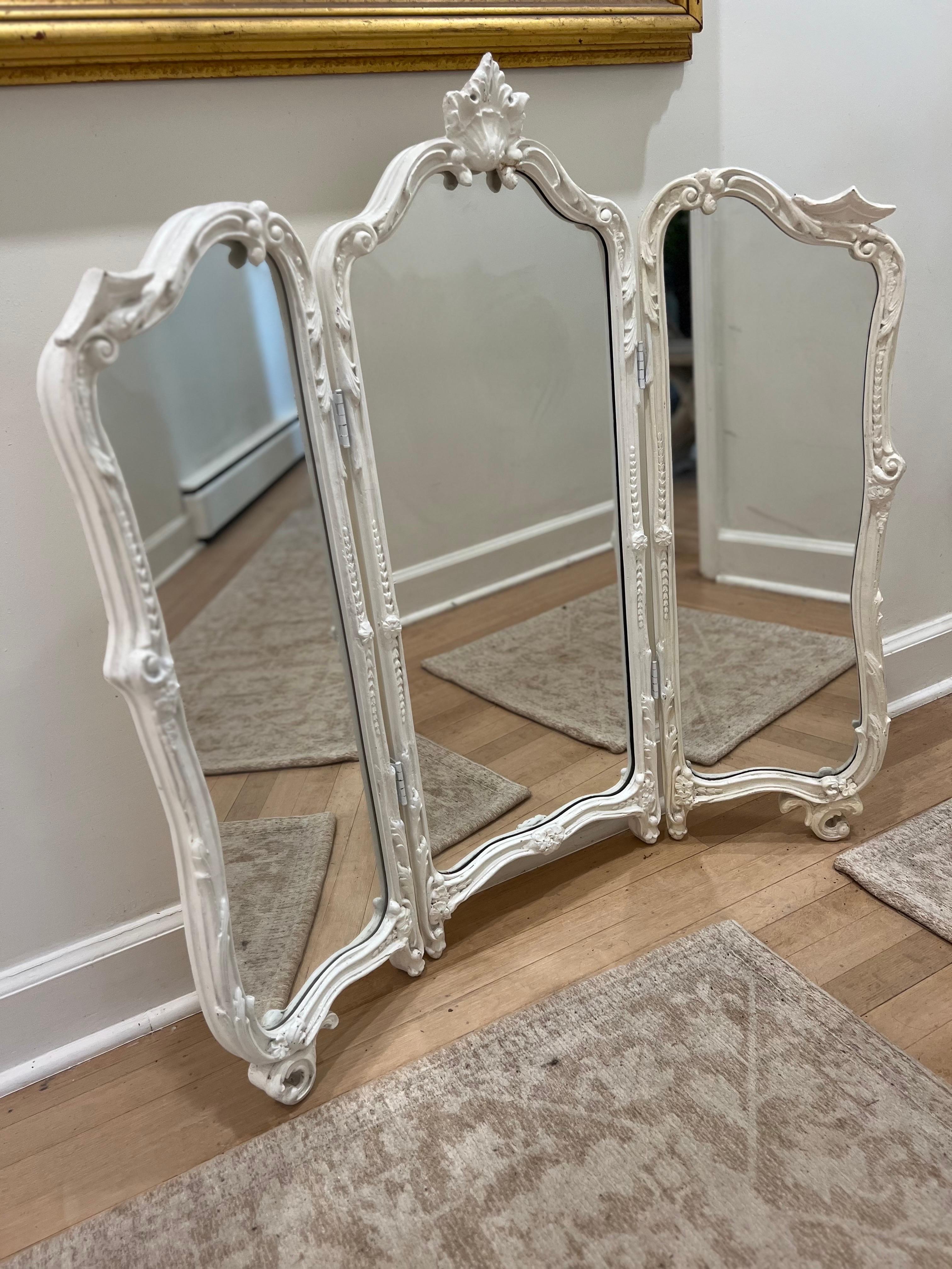 Grand miroir de courtoisie peint en blanc laqué.   Trois plis à adosser.  
