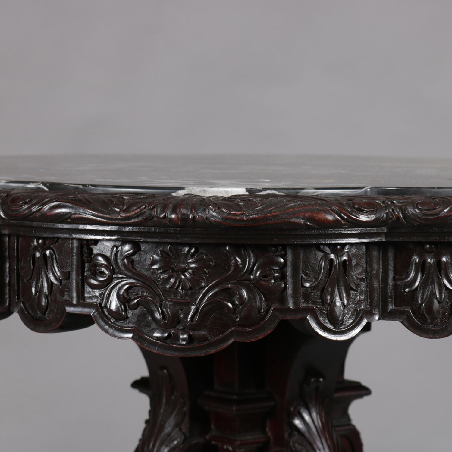 Antique French walnut centre table features scalloped top with inset marble having carved floral and foliate shaped skirt over pedestal with carved acanthus, scroll and fleur de lis, and seated on stepped base with scroll form feet with acanthus,