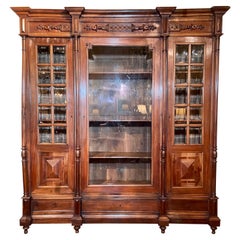 Antique French Carved Walnut Bookcase with Beveled Glass Front, Circa 1890.