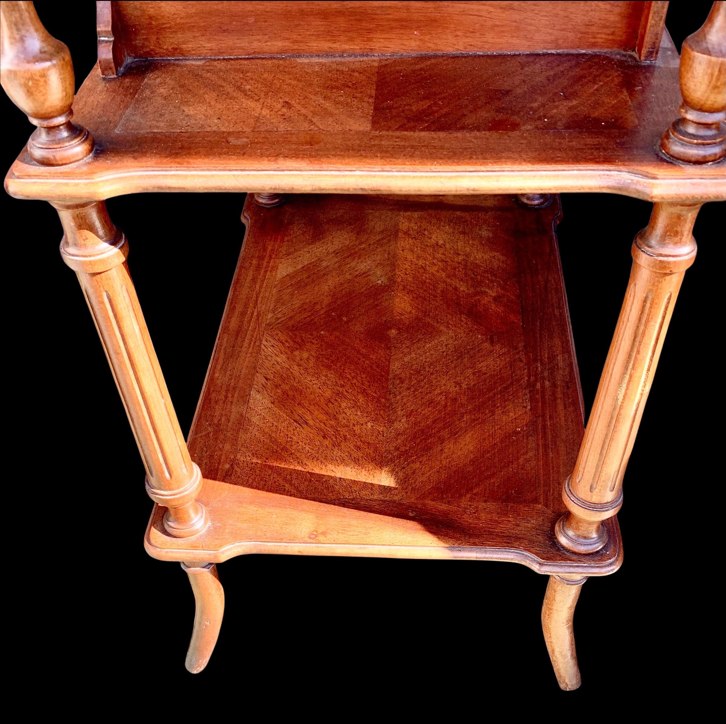 An unusual antique early 20th century French carved walnut dressing/sewing table having a beautiful, shaped chevron inlay top, the locking top lifts to reveal storage compartments and a mirror, above a set of two drawers, a lower shelf and ending in