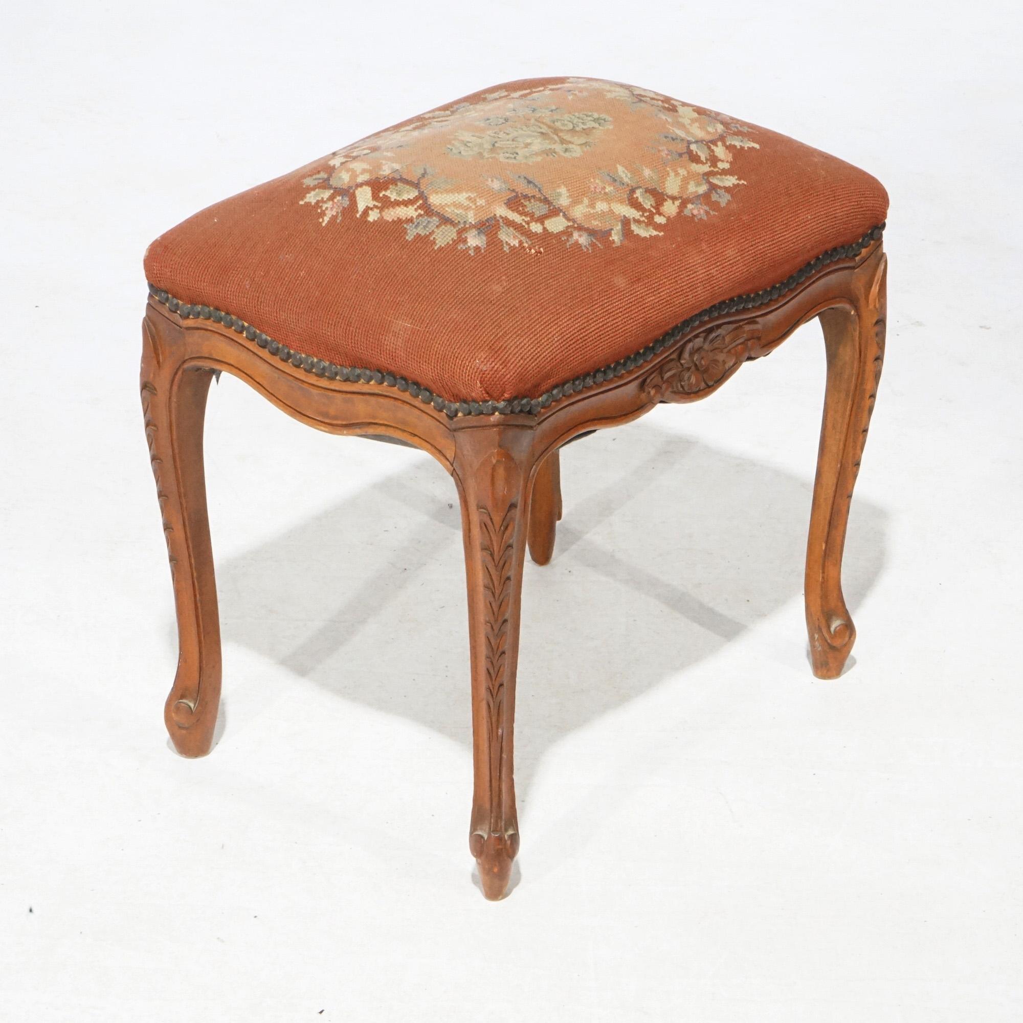 An antique French vanity bench offers needlepoint upholstered seat with floral reserve over walnut base with carved floral elements and raised on cabriole legs, circa 1920

Measures- 18.5''H x 18.5''W x 13.75''D.