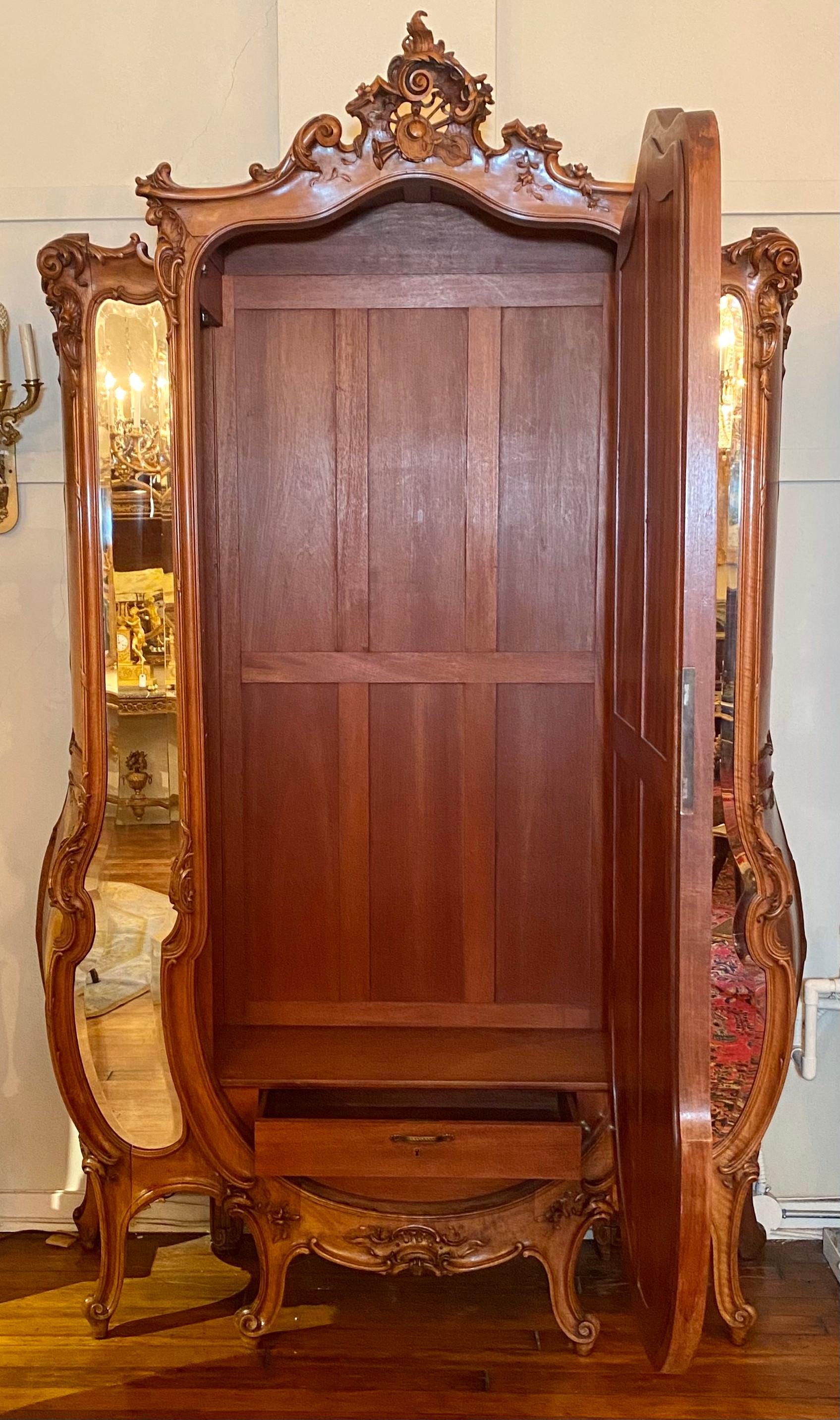 Grand antique French walnut serpentine armoire with carved detail and beveled mirrors, circa 1880.