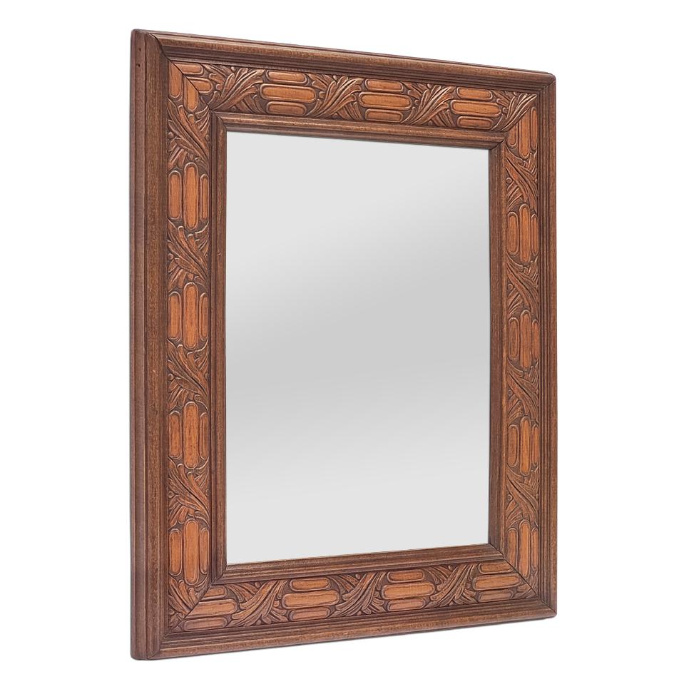 Antique French wall mirror in stained and patinated carved beech wood, circa 1940. With alternating foliage and billet decoration (Decorative architectural element : alignment of carved cylinder shapes). Frame width: 8.5 cm / 3.34 in. Modern glass