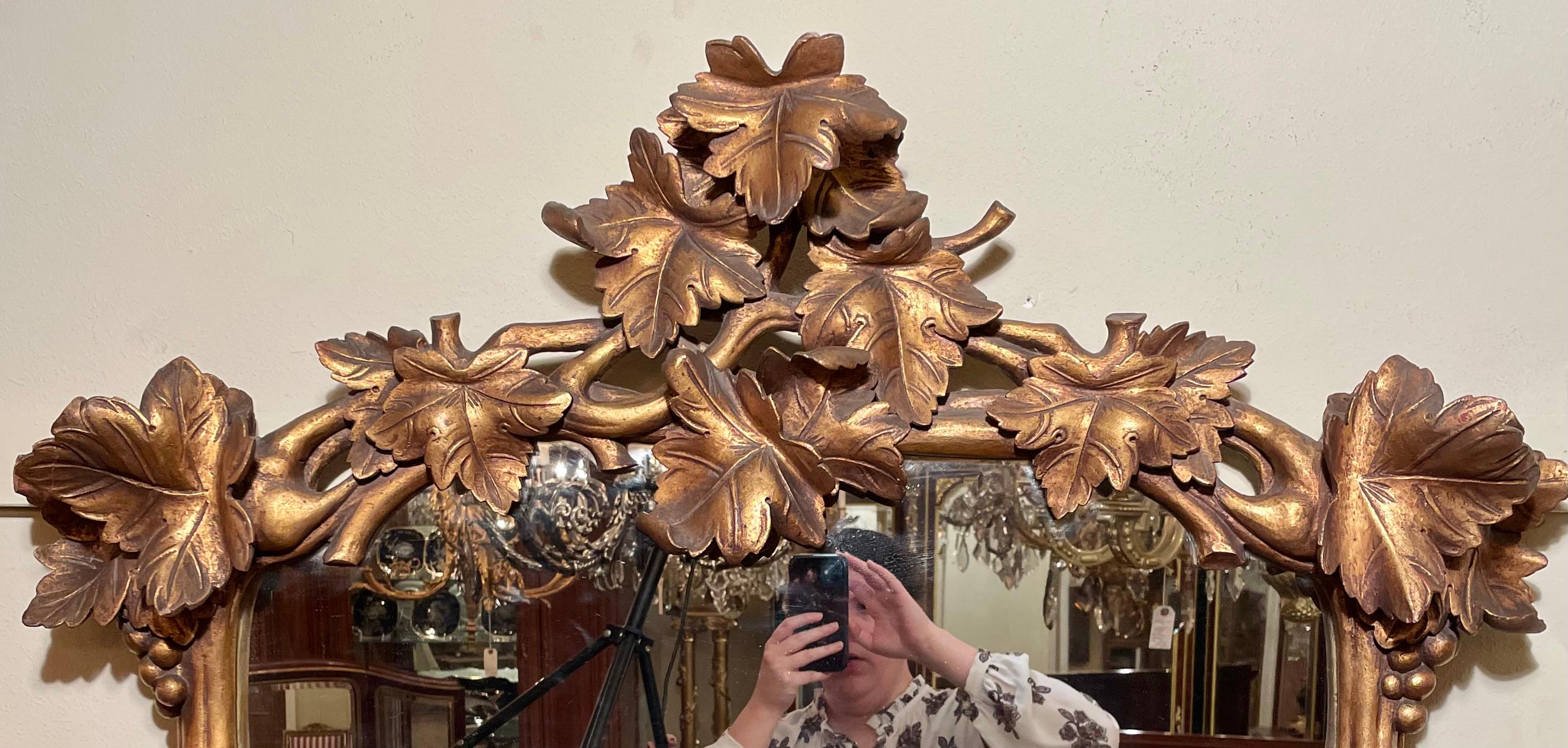 Miroir ancien en bois sculpté et feuille d'or à motif de 