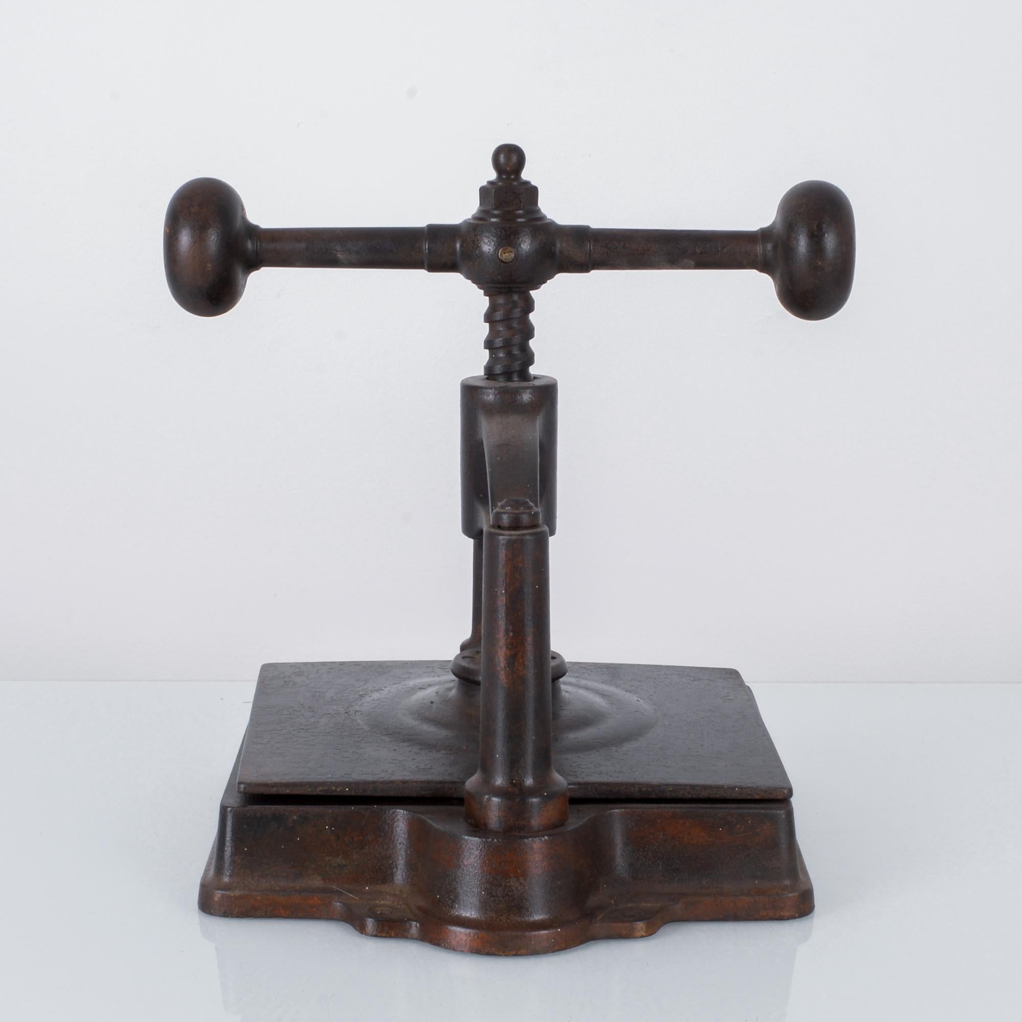 This cast iron book press with a rich patina was made in France. From the 18th-early 20th century, press machines such as this were used in offices to make copies of letters that were sent out. This press features a T-bar with rounded ends and a