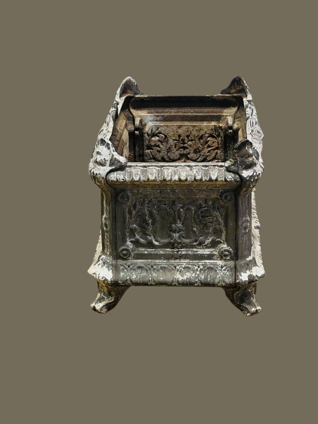 This exquisite antique French cast iron garden urn is a striking example of 19th-century European craftsmanship. Adorned with intricate relief details, including scrolling foliage and classical motifs, this planter embodies the elegance of French
