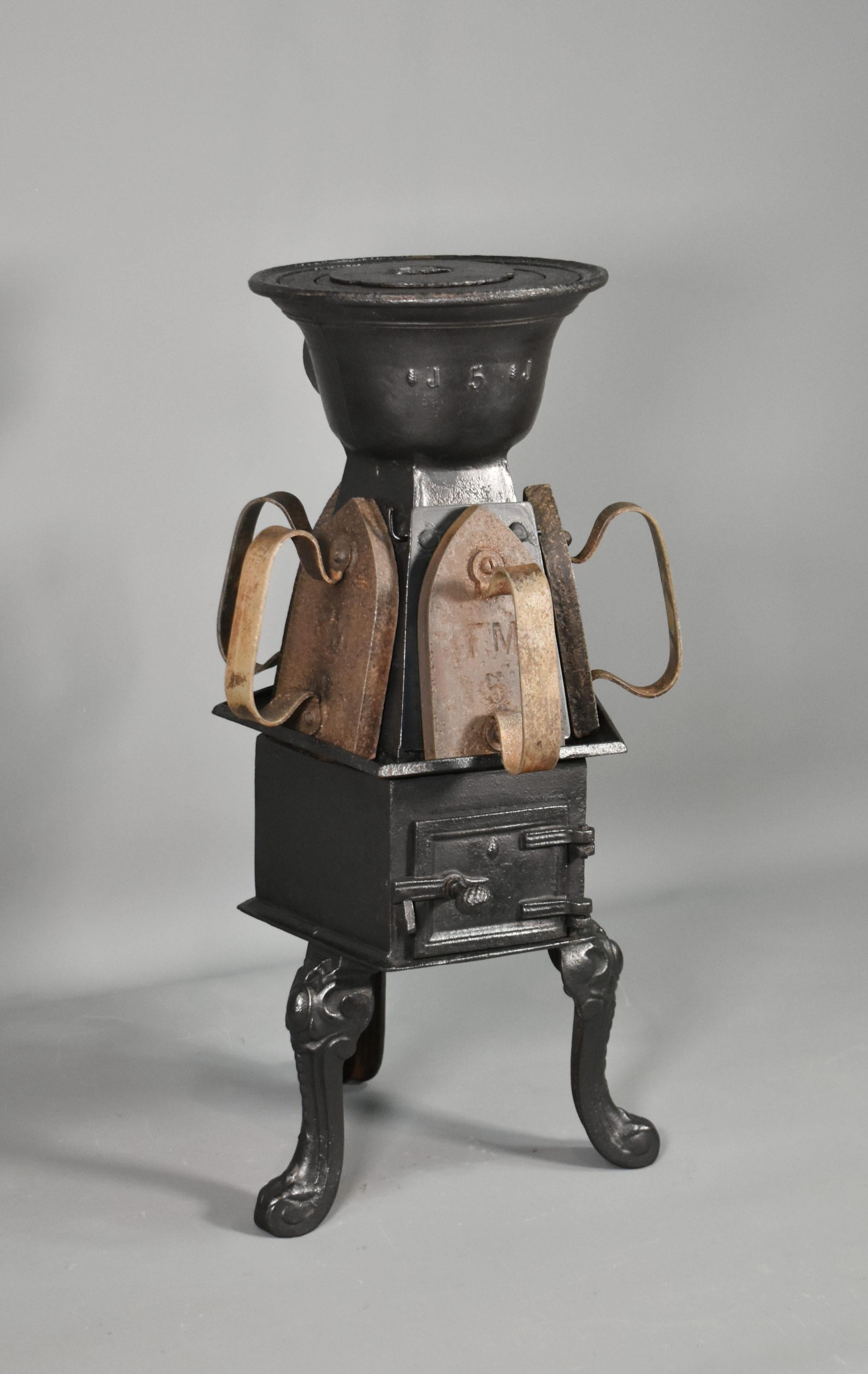Antique French Cast Iron Laundry Stove con cinque ferri da stiro tristi
 
Questa antica stufa in ghisa è realizzata in due parti e dispone di tre anelli rimovibili sulla parte superiore per le opzioni di cottura.
 
Con cinque lati inclinati