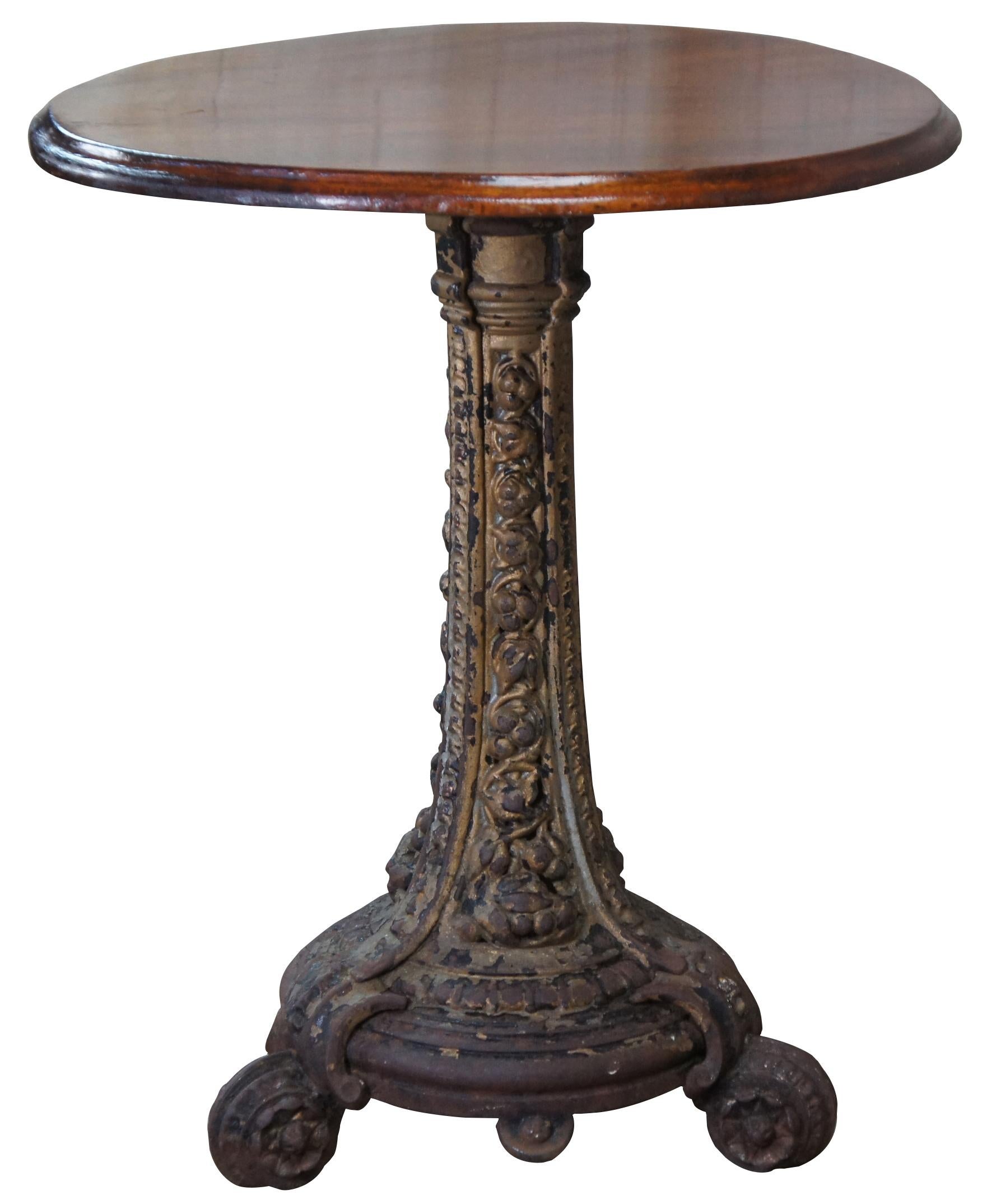 A lovely 19th century cast iron bistro or parlor table. Features a round mahogany top with ogee edge over low relief heavy floral pierced tripod base.

Measures: 24