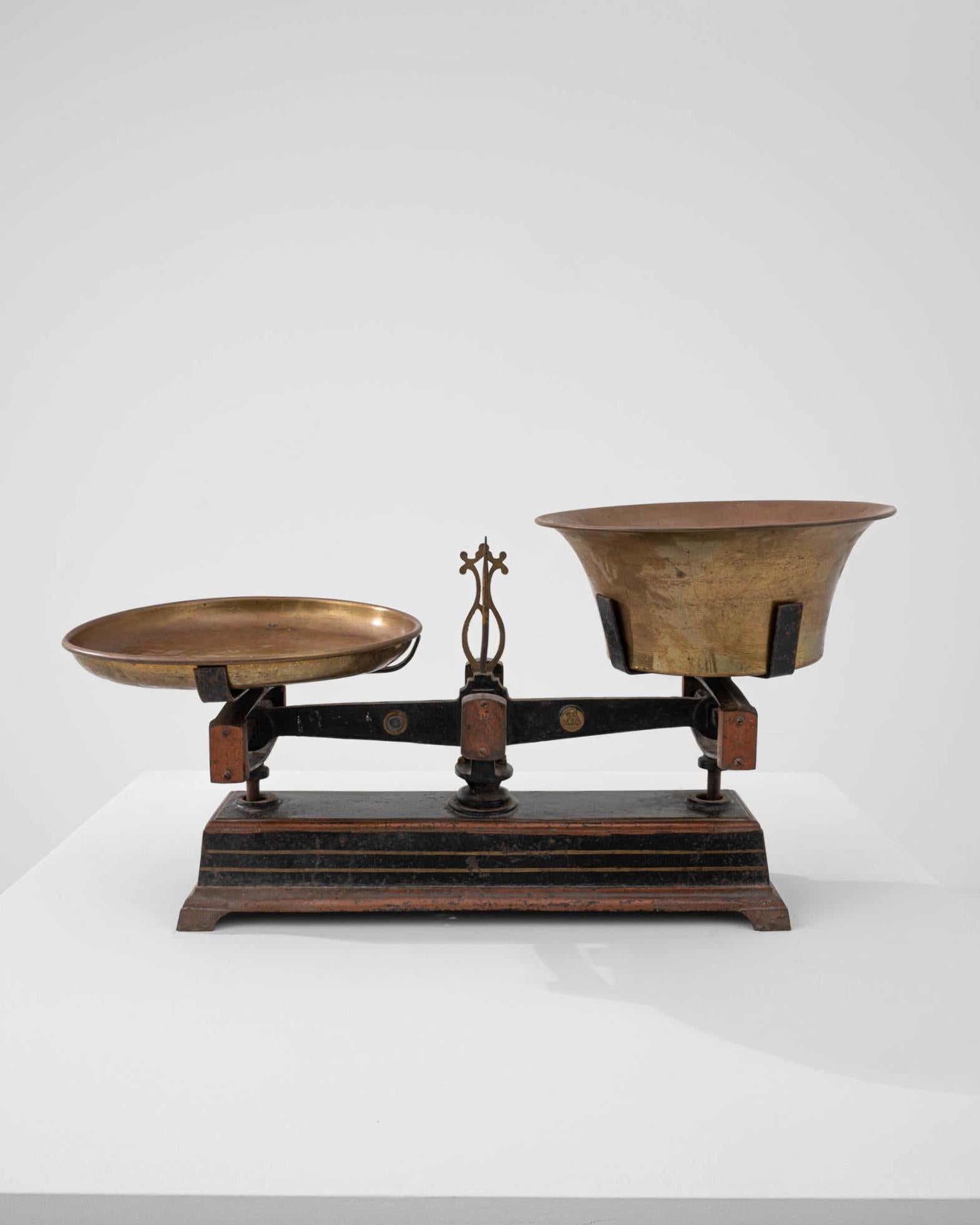 This cast iron scale was made in France, circa 1900. A ubiquitous classic in the home or the market, scales of these dimensions were commonly used to weigh fruits and vegetables. Fully functional, the scale is equipped with brass weighing pans,
