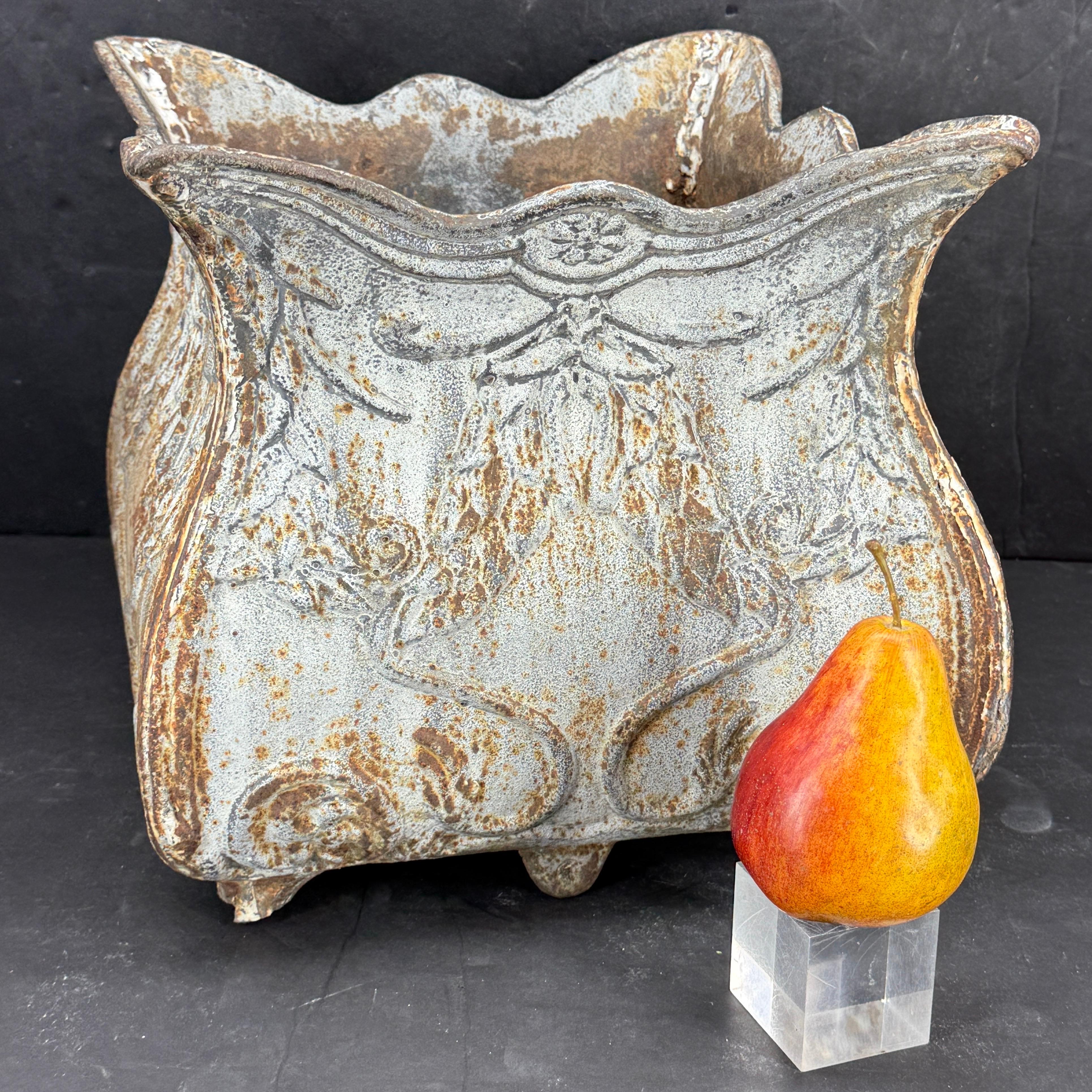 Fantastic patina on the antique French cast iron planter. Classic art nouveau flower decorated urn that could function indoors as well as outdoors. We see this piece used in many different ways such as on a console or farm table or certainly could