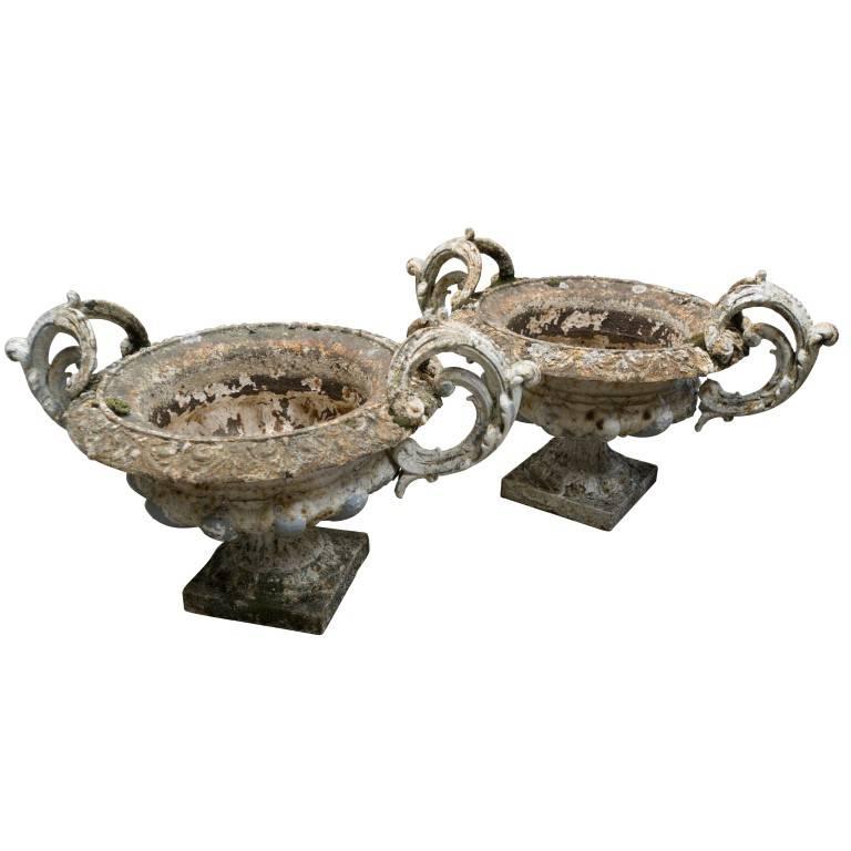Cast, these decadent urns have an abundance of detail in the perfect decorative handles and bulb fluting base giving way to the classic plinth, circa 1900. The patina of age serves to make this pair a generous sight to behold.