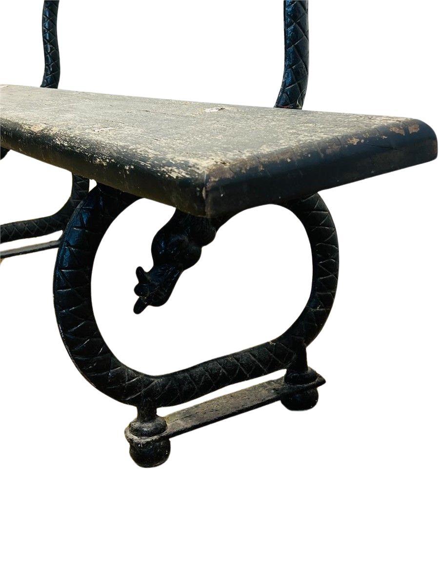 Este antiguo banco de parque francés es una pieza bellamente envejecida que presenta una robusta base de hierro fundido con intrincados detalles de volutas y listones de madera desgastados. Perfecto para interiores y exteriores, captura la elegancia
