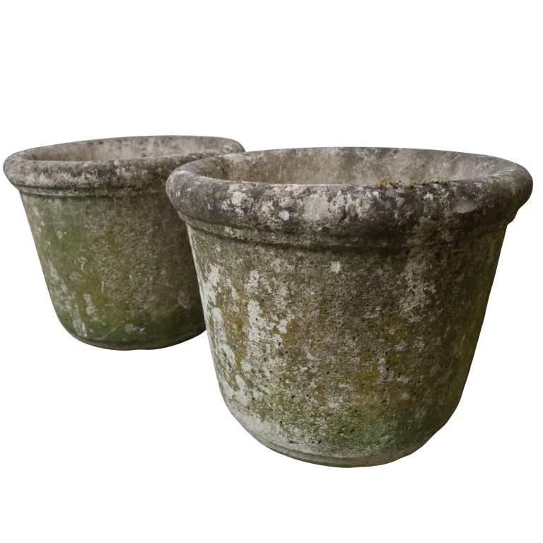 Available individually or as a pair these urns are petite and heavy. Patina born of the French country side covers these urns in a lovely shade of green mixed the grey tones of natural use in the garden combined with its original stone cement color.