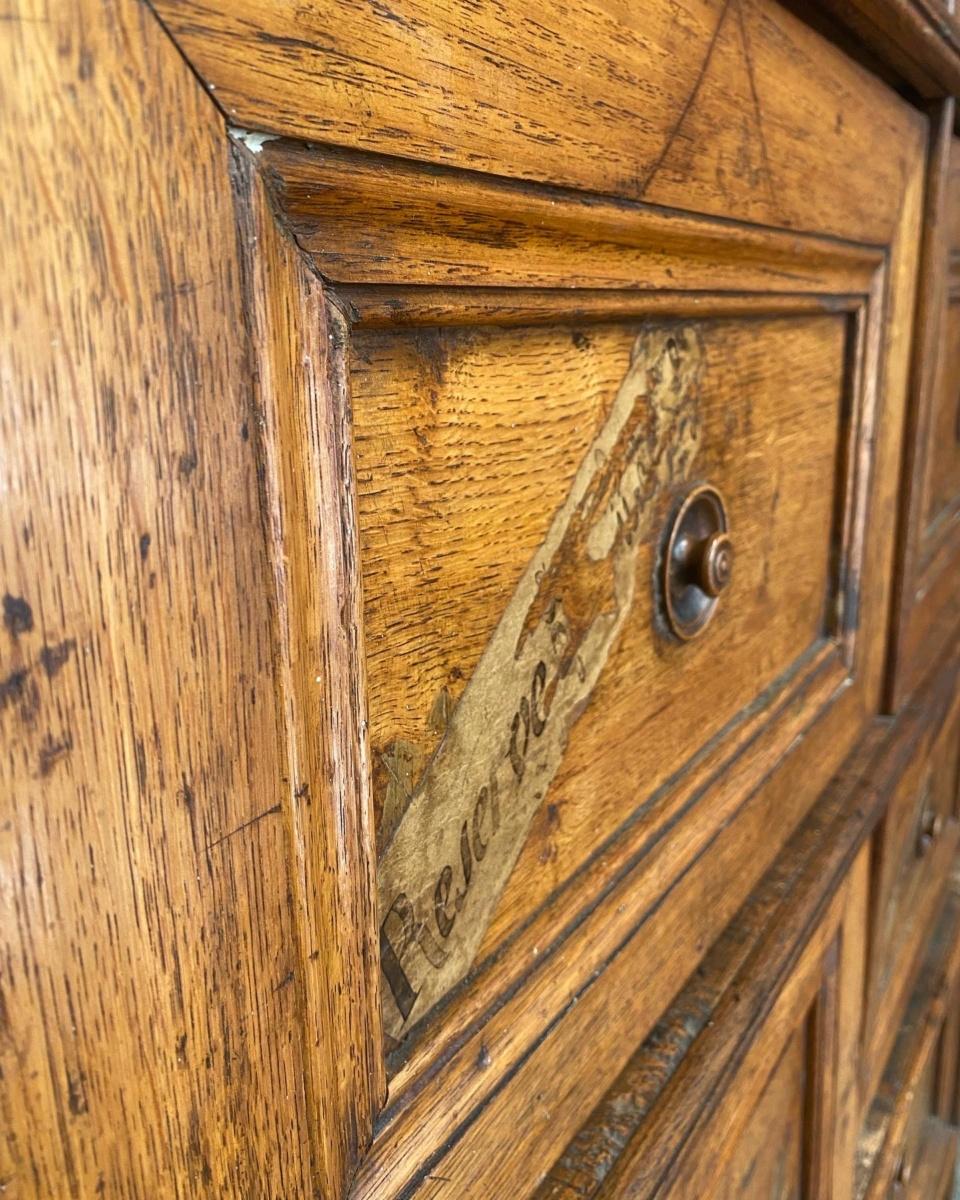 Antique French 19th century oak & pine apothecary shop cabinet cupboard.
An exquisite and charming, antique 19th century French light oak and pine shop haberdashery cabinet.
Fitted with two rows of five lift up compartments, some with remains of