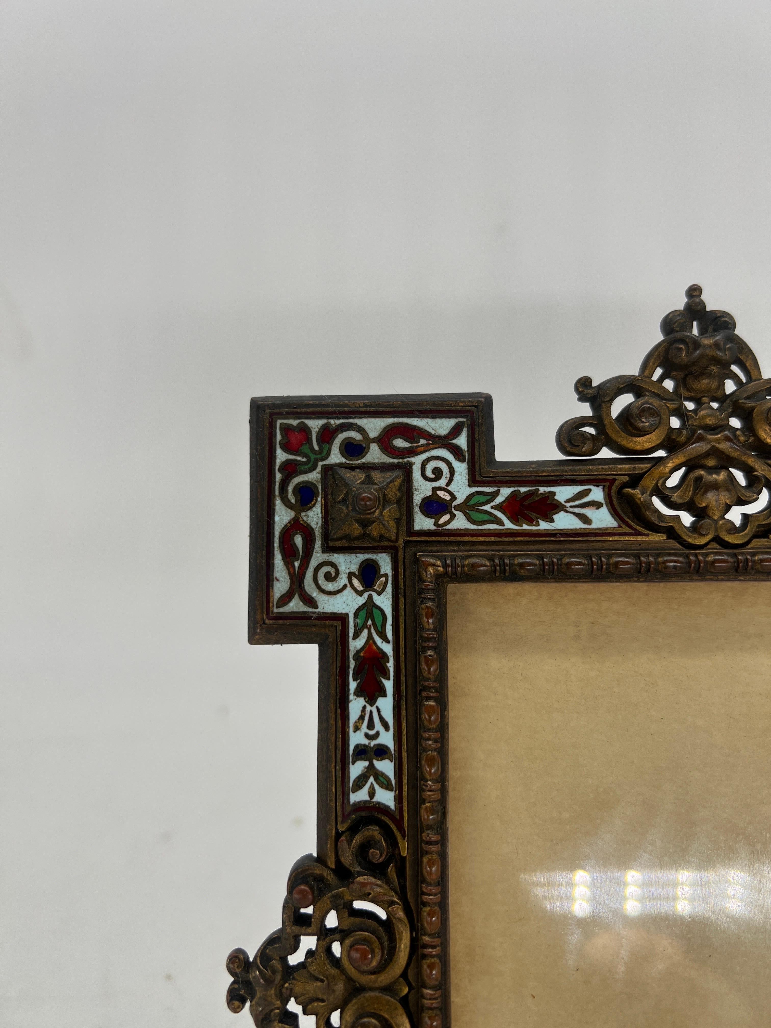 French, Circa 1890.

An antique French champleve enamel picture frame with a Renaissance Revival styling. Beautiful bronze scroll work accents the blue and floral enameled edge.