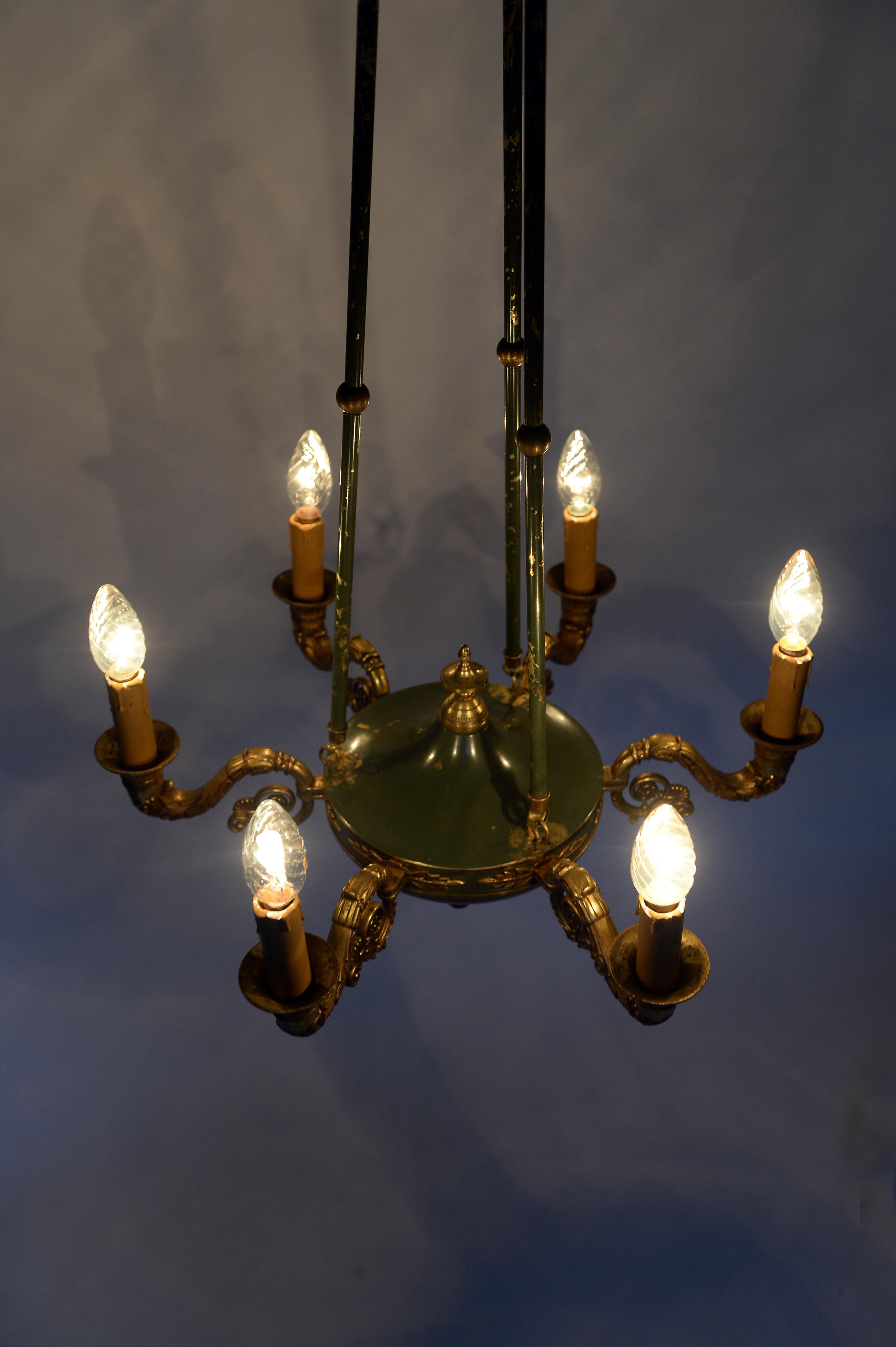Antique 6 branch ormolu chandelier made from gilt metal.

The chandelier has a grey or blue painted centre piece showing some wear.

It consist of 3 suspension rods and is decorated with ormolu finials.

Beautiful original condition