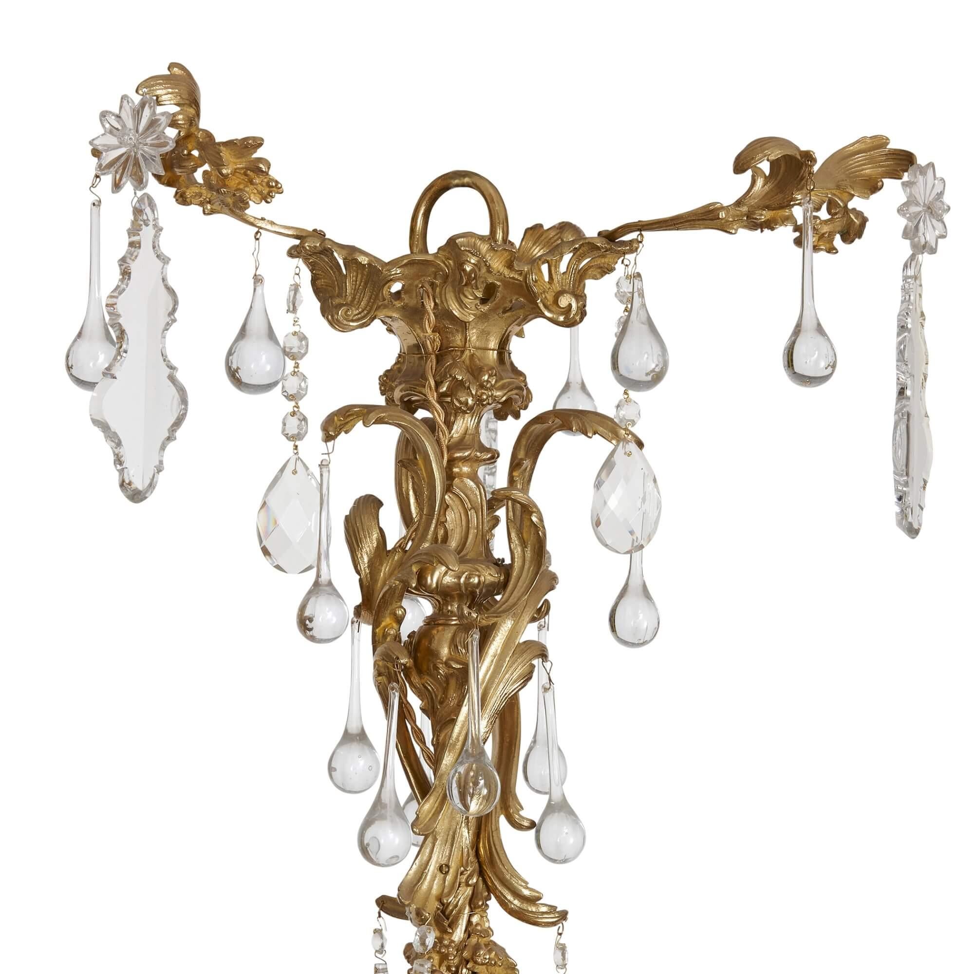 Antique ormolu and cut-glass Rococo-style chandelier 
French, 19th Century 
Height 130cm, diameter 90cm

This Rococo-style chandelier is filled with the opulent details that characterised the period. From the central ormolu stem extend twenty-four