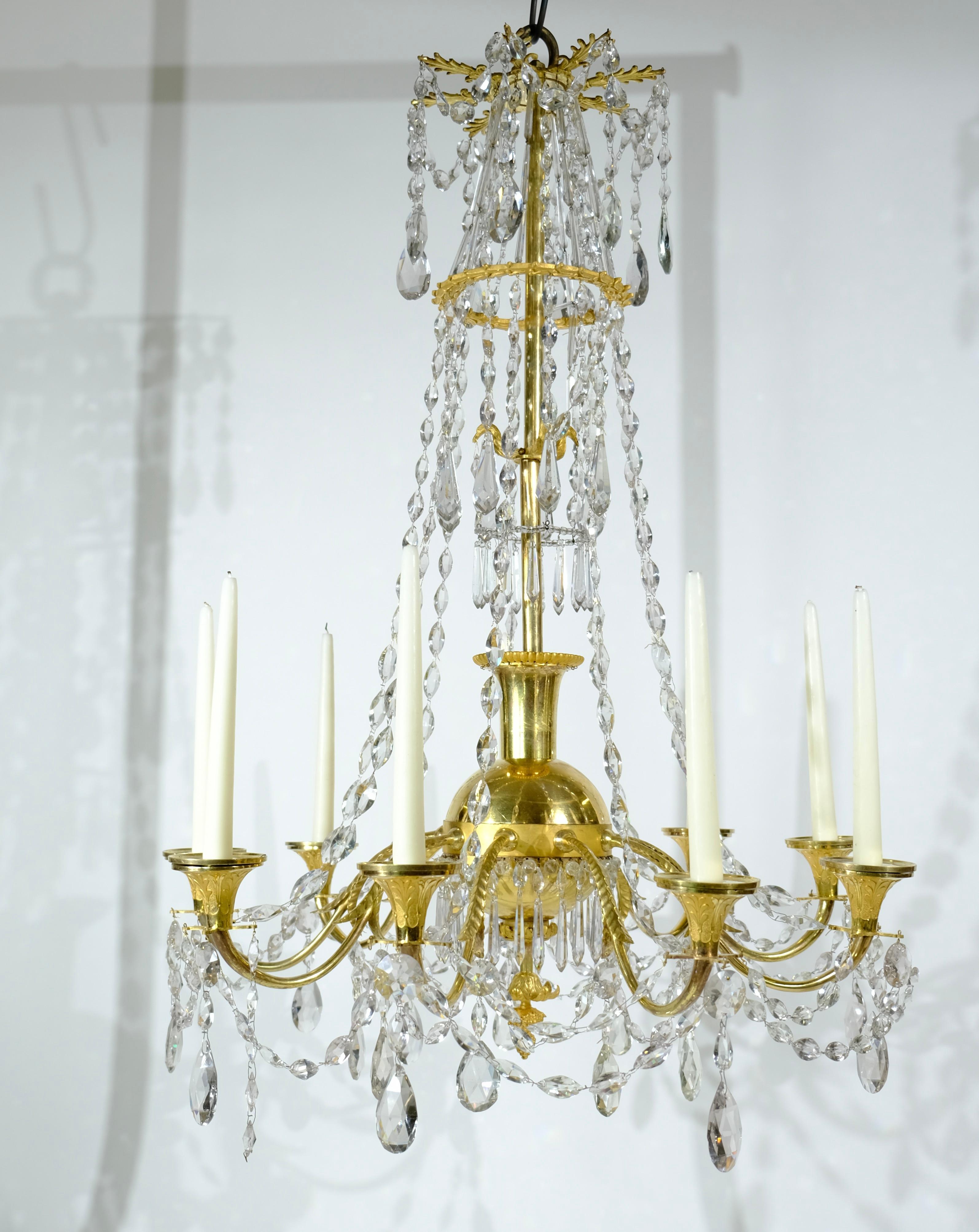 A high quality Directoire chandelier. All arms, candleholders and central stem are cast in bronze and then gilt. The quality of the craftsmanship is of the highest level. The crystals are beautifully arranged around the chandelier and also these are