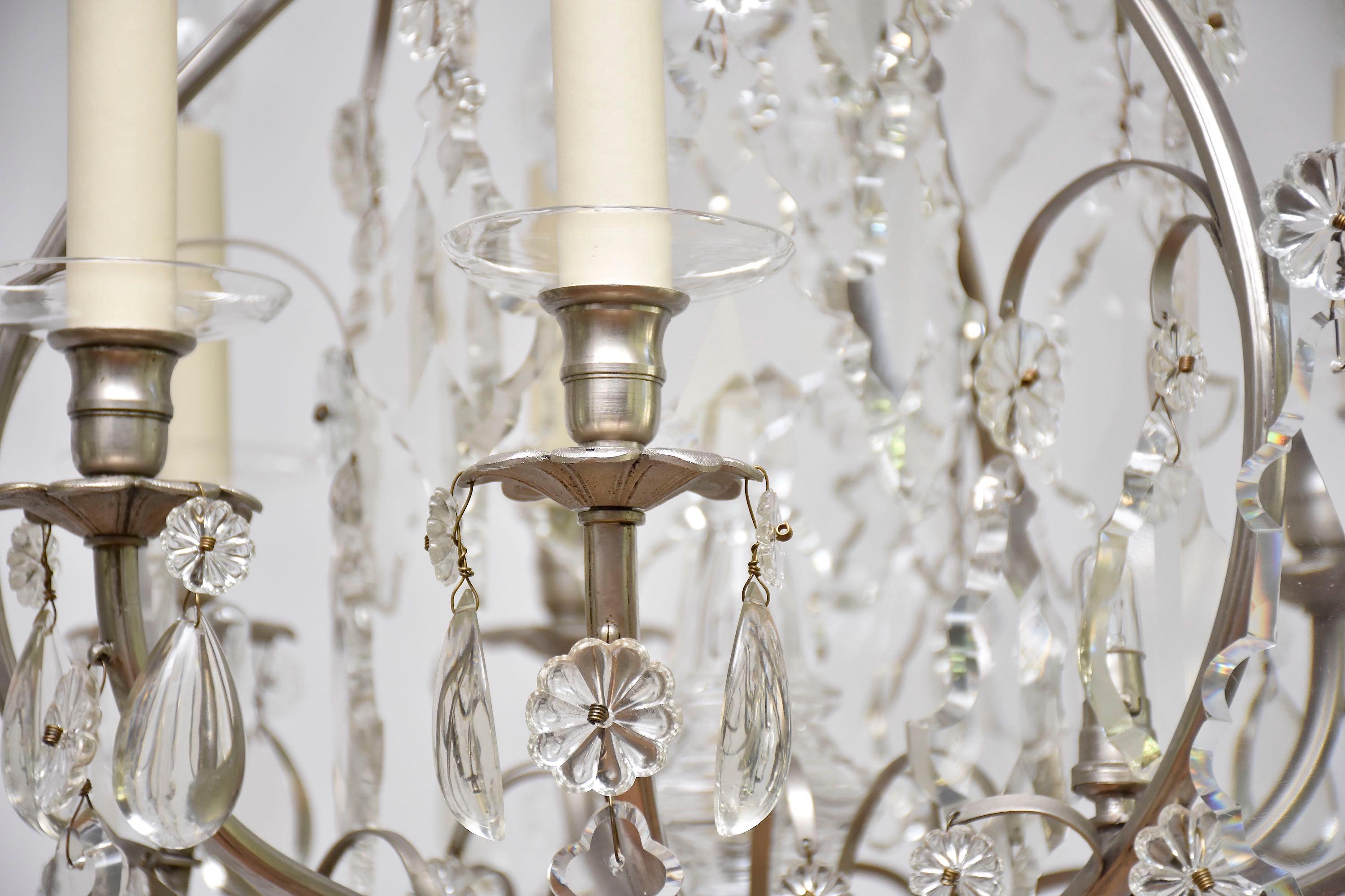 Magnifique lustre en cristal avec 6 lumières autour du lustre et 4 petites lumières à l'intérieur.
Forme de cage ; 
Au centre se trouve un poignard en cristal avec un luminaire supplémentaire.
L'ensemble du lustre est richement orné de magnifiques