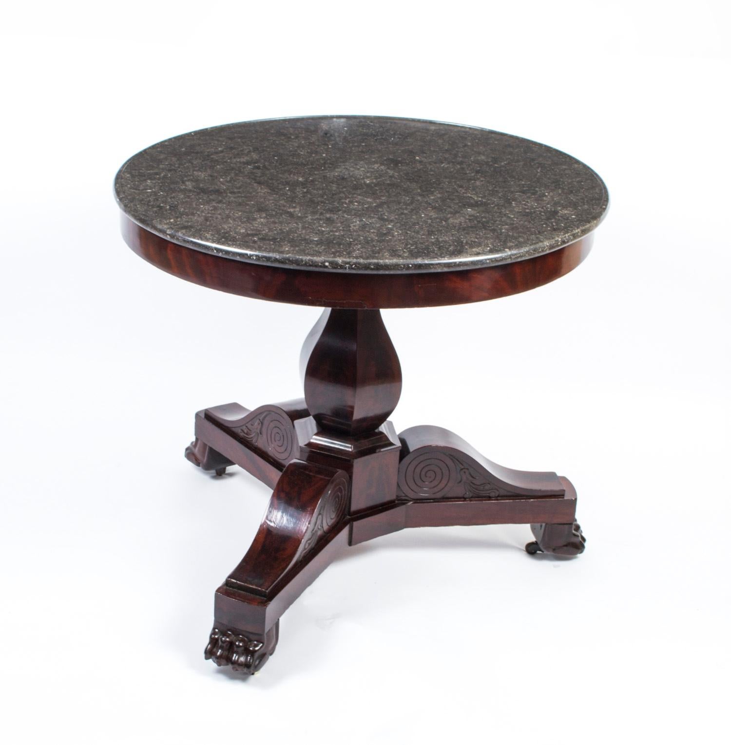 This is a handsome antique Charles X centre table, circa 1820 in date.

It is masterfully crafted in a deep rich flame mahogany with a central tulip column, three beautifully shaped scroll pedestal legs with lion's paw feet. 

It is surmounted with