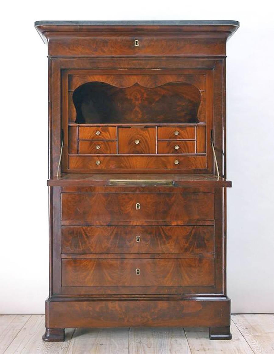 A Charles X secrétaire à abattant in mahogany, France, circa 1825. Fall-front has original counter weight for ease in lowering and closing. Dark green tooled leather on desk top appears to be the original, as well as all extant locks which are