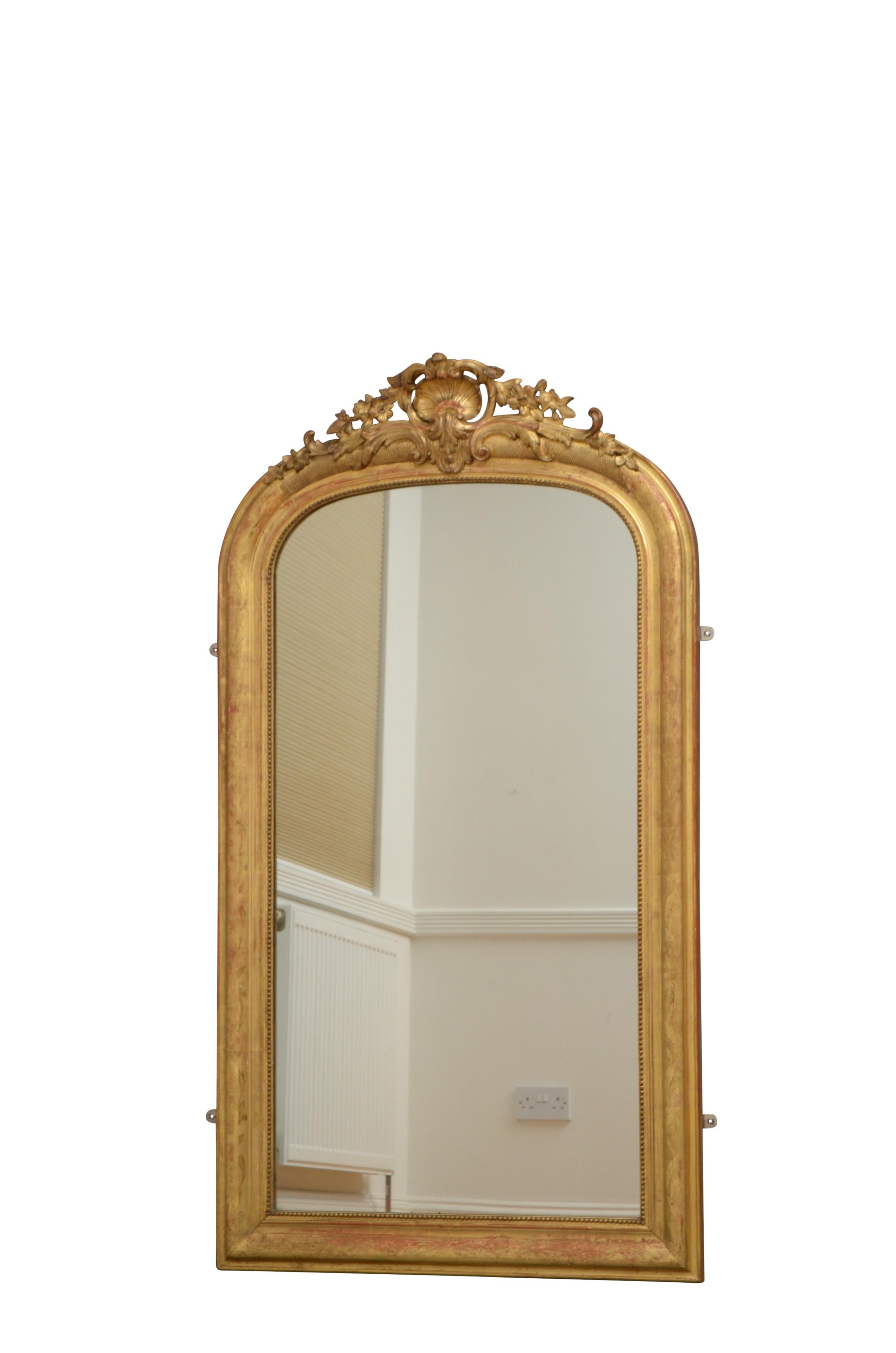 K0436 Antiguo espejo de muelle o espejo de pared de madera dorada del castillo francés del siglo XIX, de esbeltas proporciones, con espejo original algo descolorido en un marco finamente decorado con motivos florales grabados y una elaborada cresta