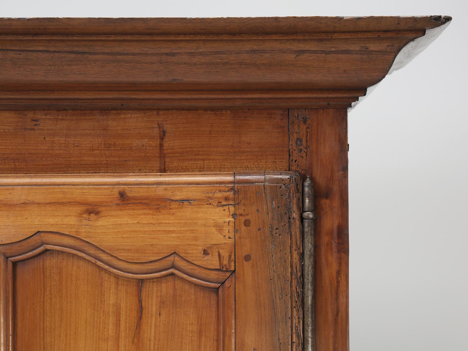 Antique French bonnetiere made from solid cherrywood and probably was constructed in the late 1700s. The cherrywood, of our bonnetiere or small armoire or cupboard, has a beautiful and natural patina to it. Both the upper and lower doors of our