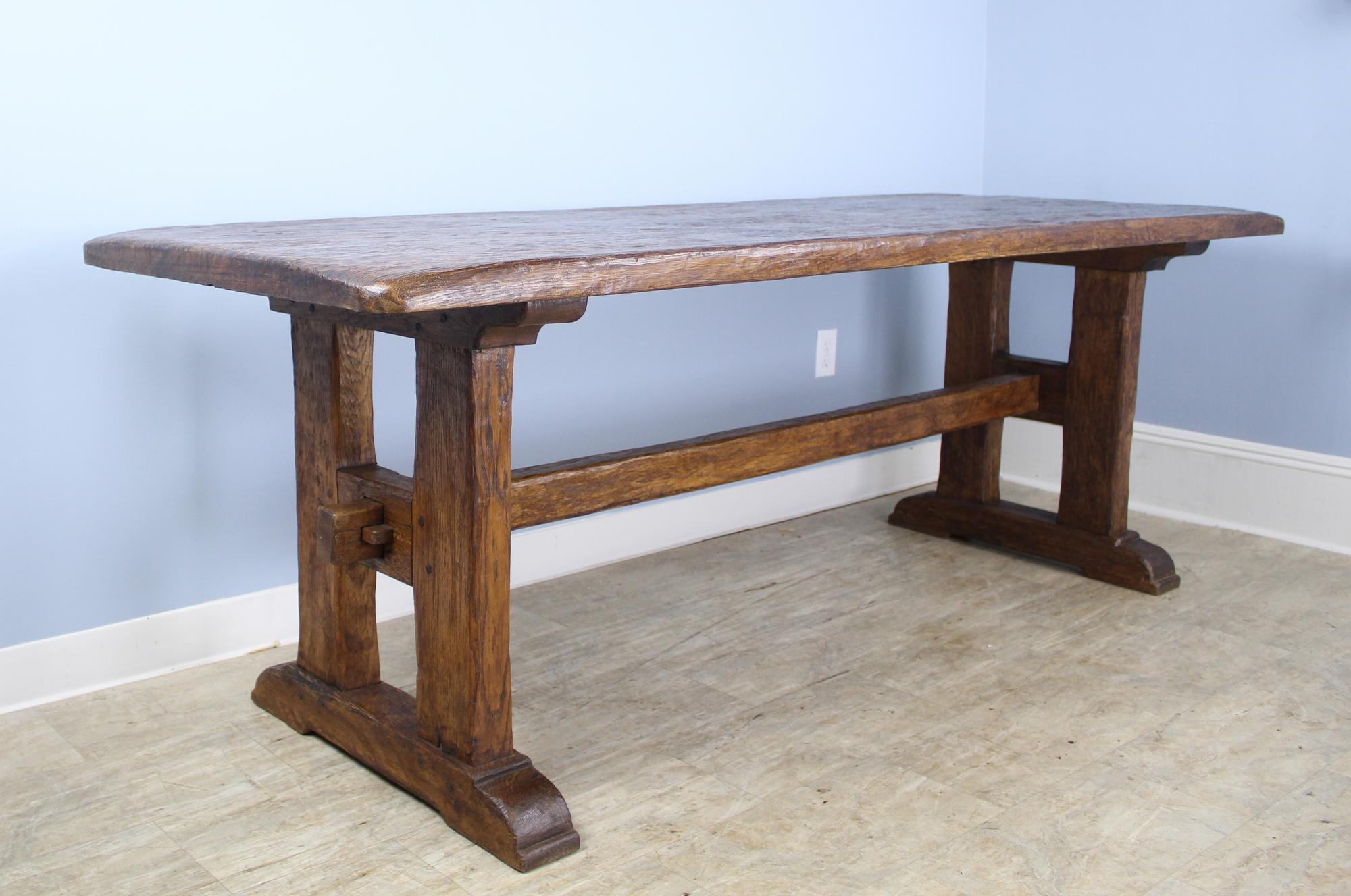 A handsome and beautifully crafted antique French refectory table with a 2 inch thick top and marvelous construction and design on the trestle base. The chip carving on the tabletop adds an additional note of interest. With no apron or legs to get