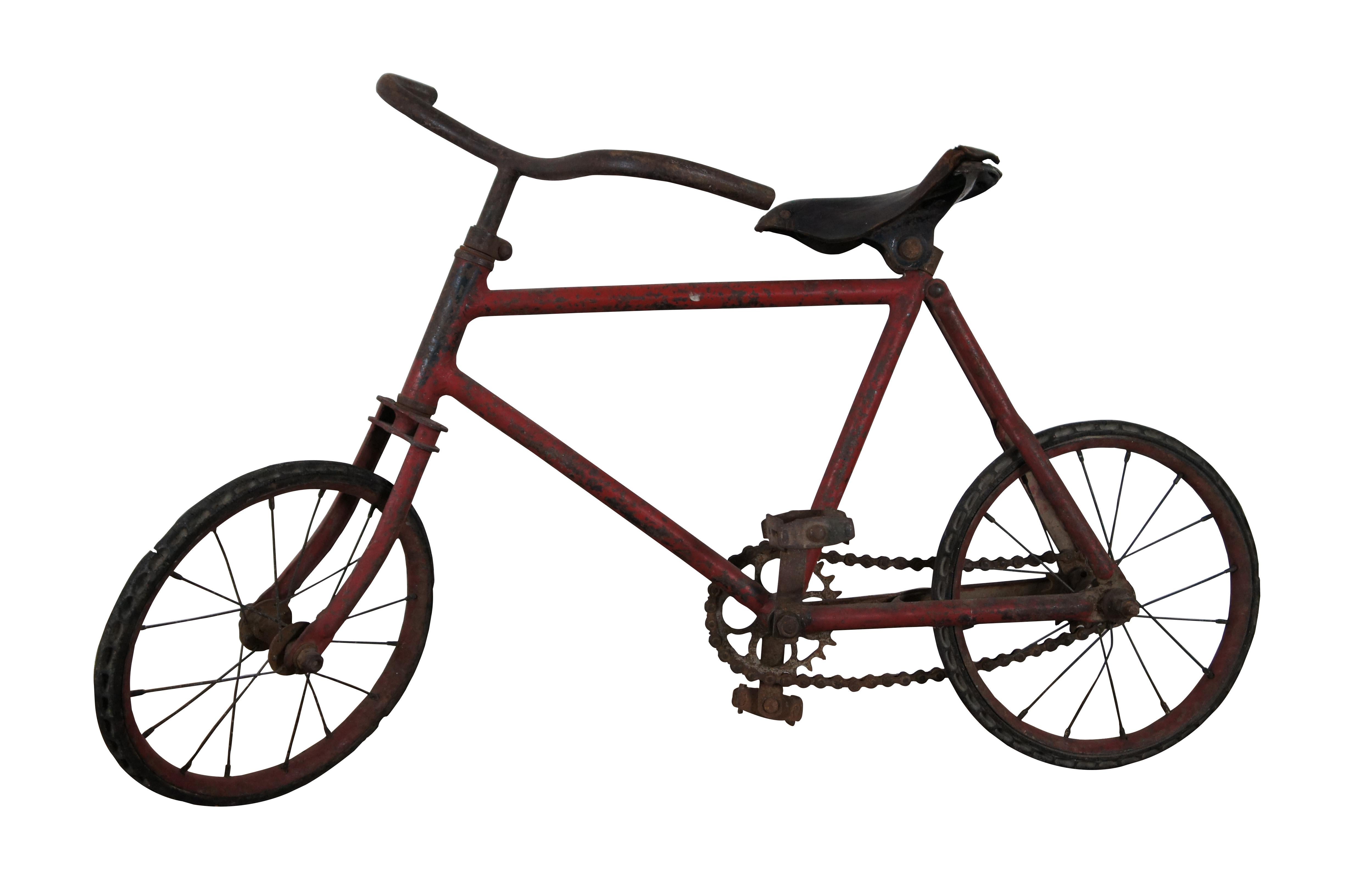 Antique early 20th century French child’s bicycle, crafted of red painted metal with hard rubber tires and leather covered seat. Measure: 32