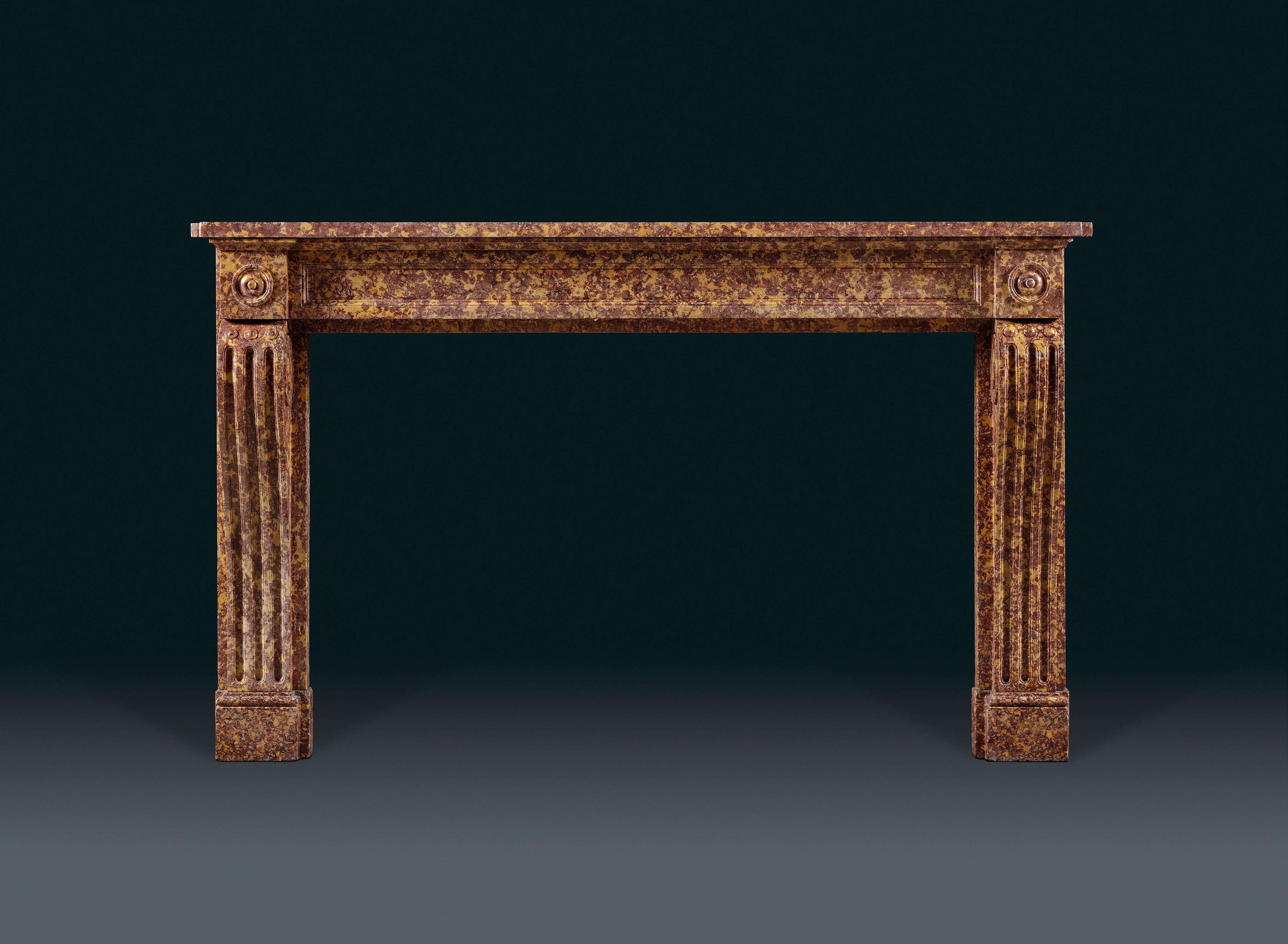 A 19th century French Brocatello marble chimneypiece of good color of Louis XVI style with rectangular shelf above the plain inset frieze which is flanked by square blockings carved and decorated with rounded paterae. The scrolled console jambs