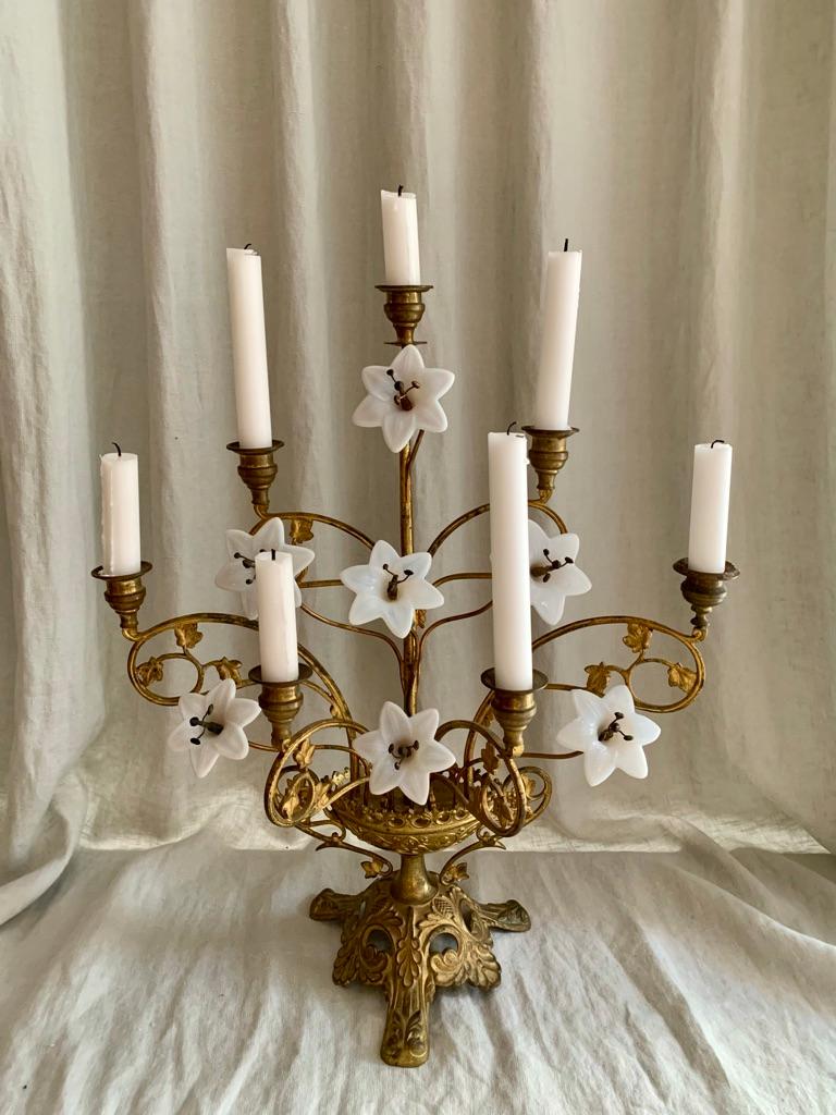 Large antique French gilded brass church candelabra decorated with opal glass lilies, and foliage leafs. The candelabra can hold seven candles. These antique French candelabras used to adorn the catholic churches throughout France and they add so