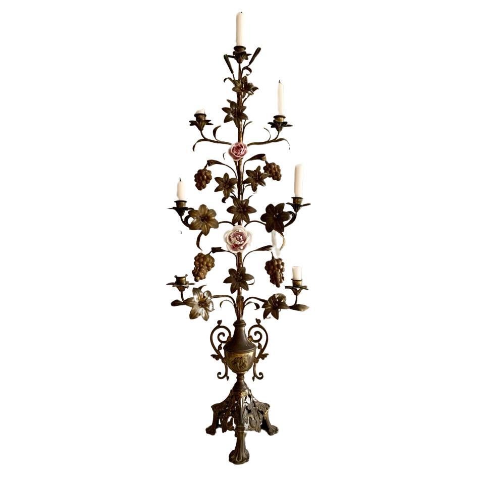 Large antique French gilded brass church candelabra decorated with lilies, grapes, leafs and delicate porcelain flowers. The candelabra can hold seven candles. These antique French candelabras used to adorn the catholic churches throughout France