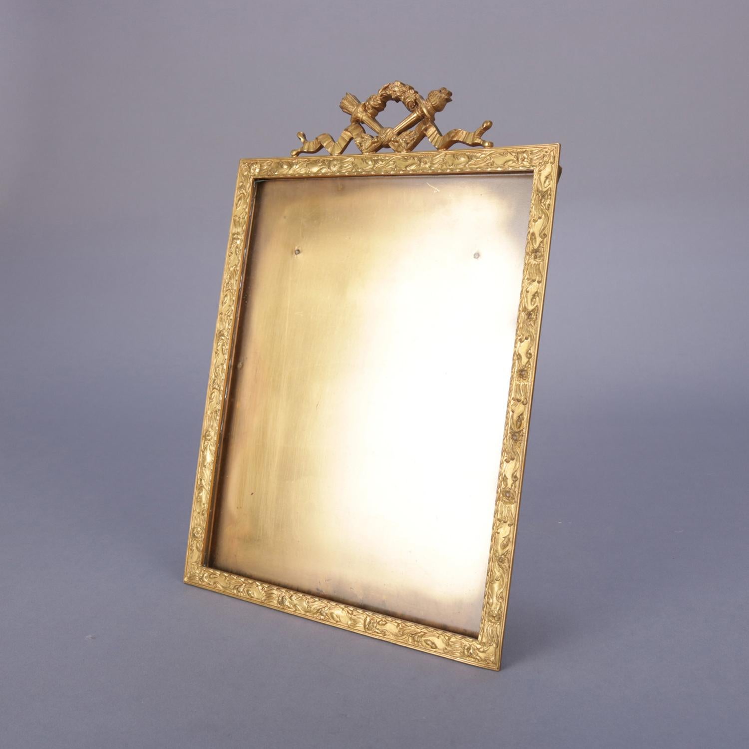An antique French Classical Empire ormolu picture frame by Baltman & Co., New York features foliate embossed border with crest having Victory torch and quiver, stamped on stand B. Altman, circa 1890.

Measures: fr: 12.5