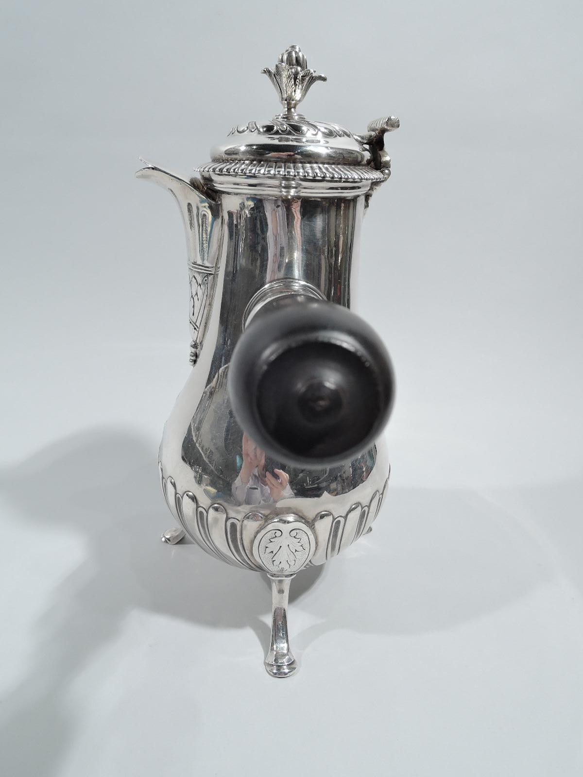 French Classical silver coffeepot, 18th century. Baluster with silver-mounted stained and turned wood handle. Cover hinged with bud finial. V-form fish-mouth spout. Three hoof supports with oval medallion mounts. Gadrooning, twisted fluting, and