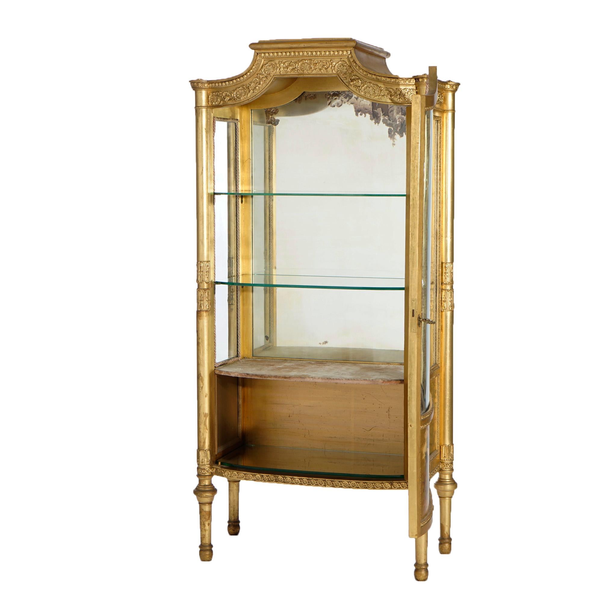 An antique French vitrine offers giltwood construction with pagoda form crest having floral and foliate elements over case with single glass door opening to shelved and mirrored interior, Vernis Martin Classical scene with woman and cherubs in
