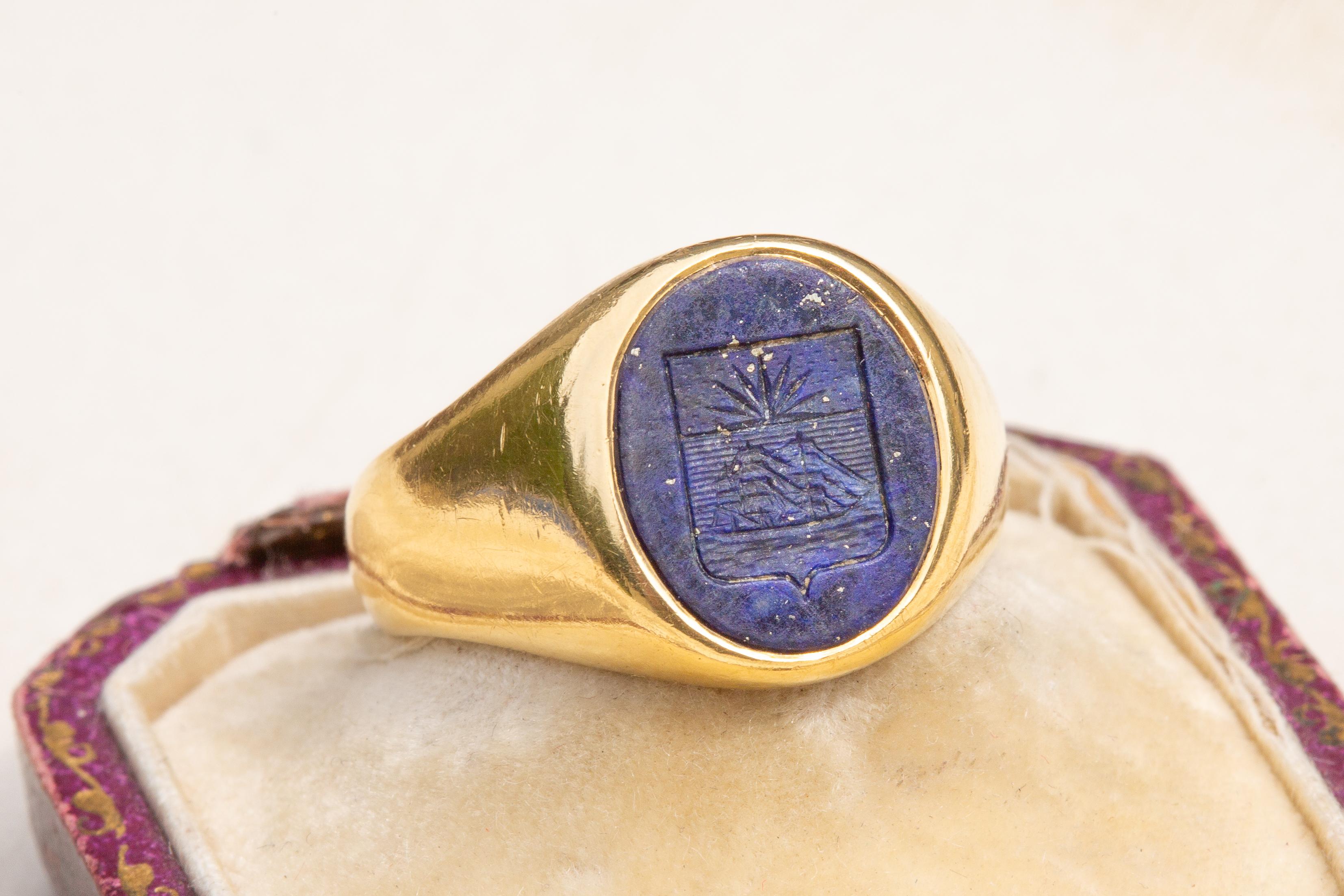 This fantastic gold signet ring dates to the early 20th century, circa 1910 and was made in Paris. A vibrant lapis lazuli is engraved with a French heraldic family coat of arms. 

The carved lapis lazuli displays a gorgeous blue hues with evenly