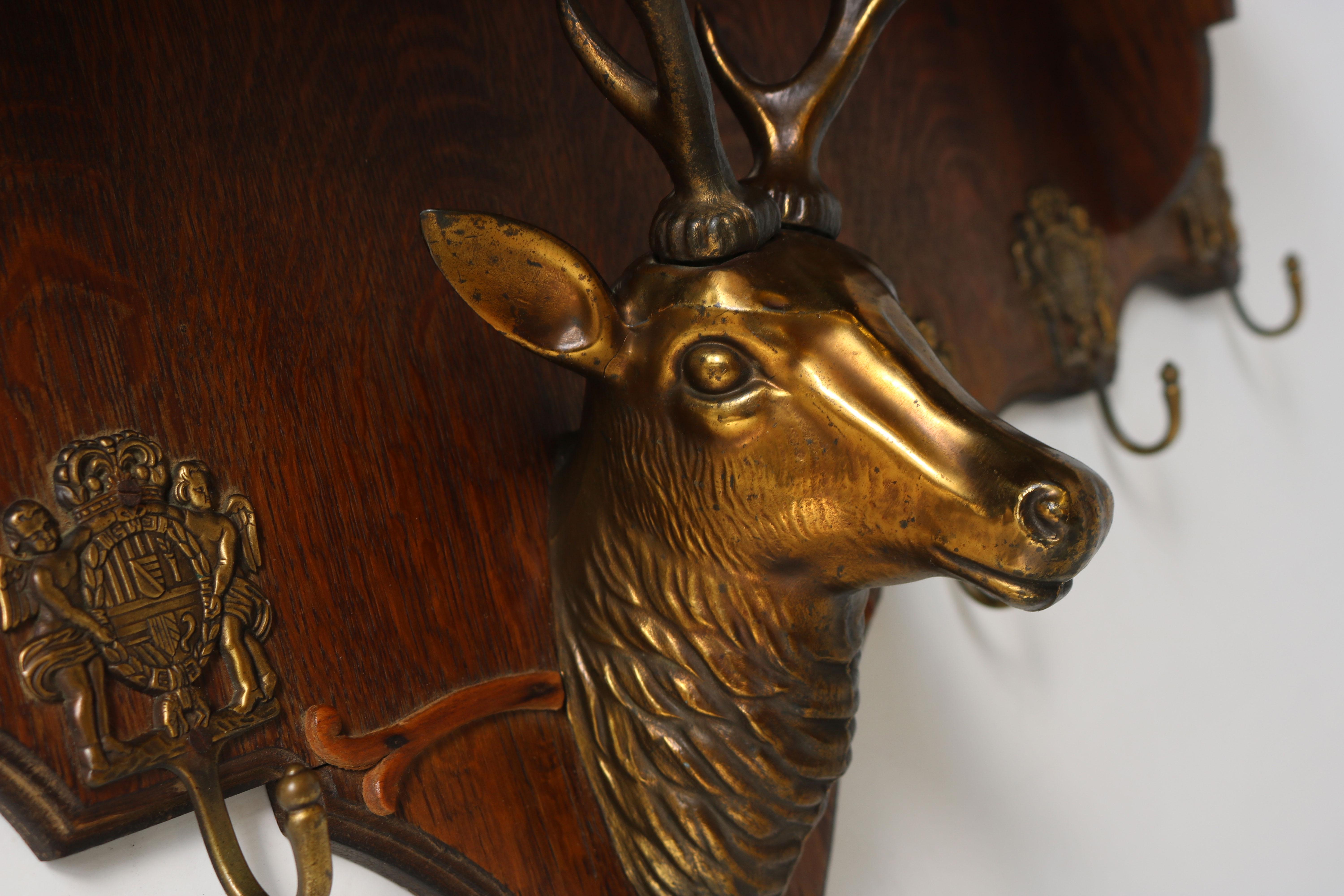 Gorgeous & unique antique coat rack from France 1940's. 
The coatrack has a large brass deer head that uses his antlers to support the hat rack. 
The coat rack is made out of oak and has 6 nicely decorated original hooks. 
It is in nice antique