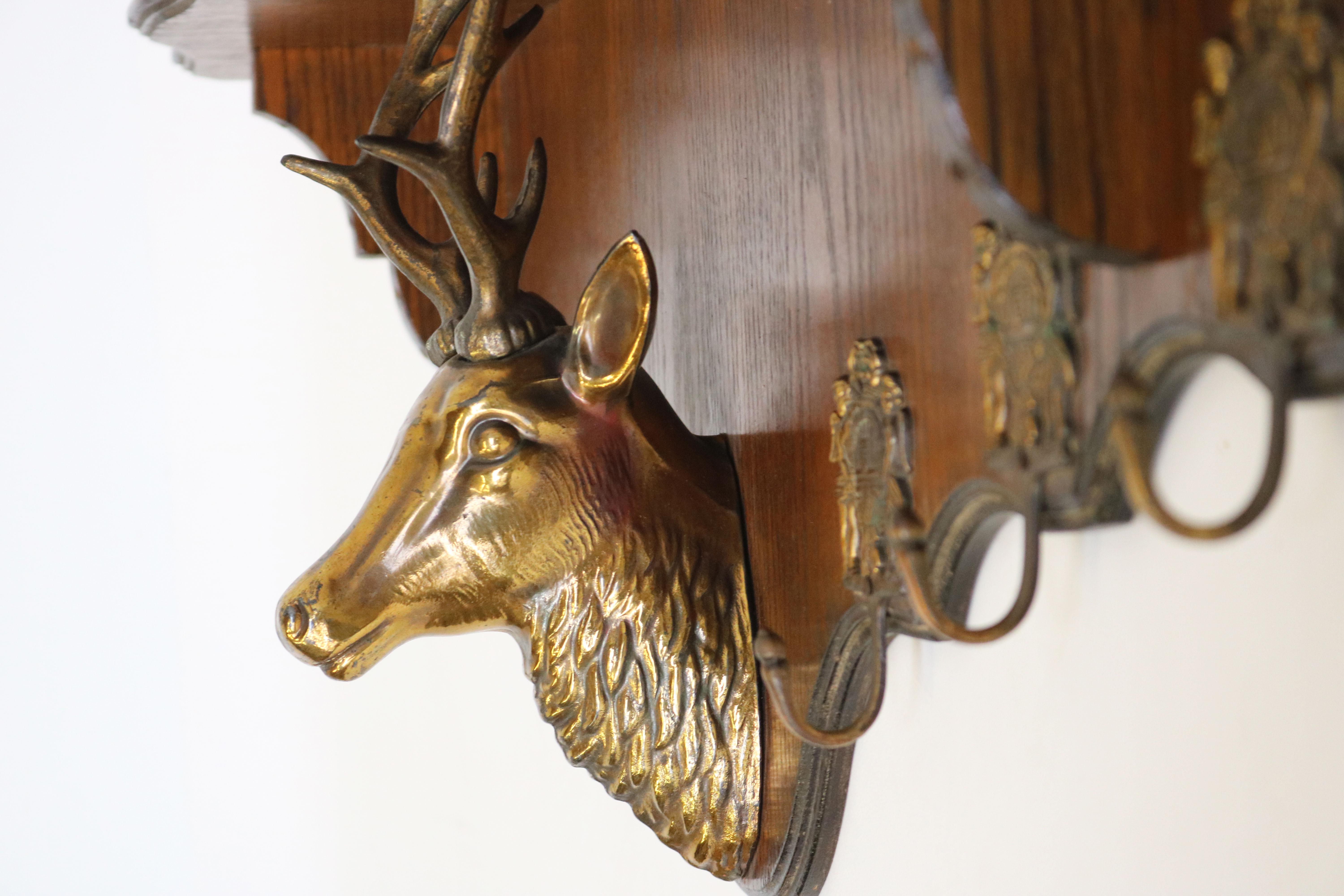 Gorgeous & unique antique coat rack from France 1940's.  
The coatrack has a large brass deer head that uses his antlers to support the hat rack.  
The coat rack is made out of oak and has 6 nicely decorated original hooks.  
It is in nice antique