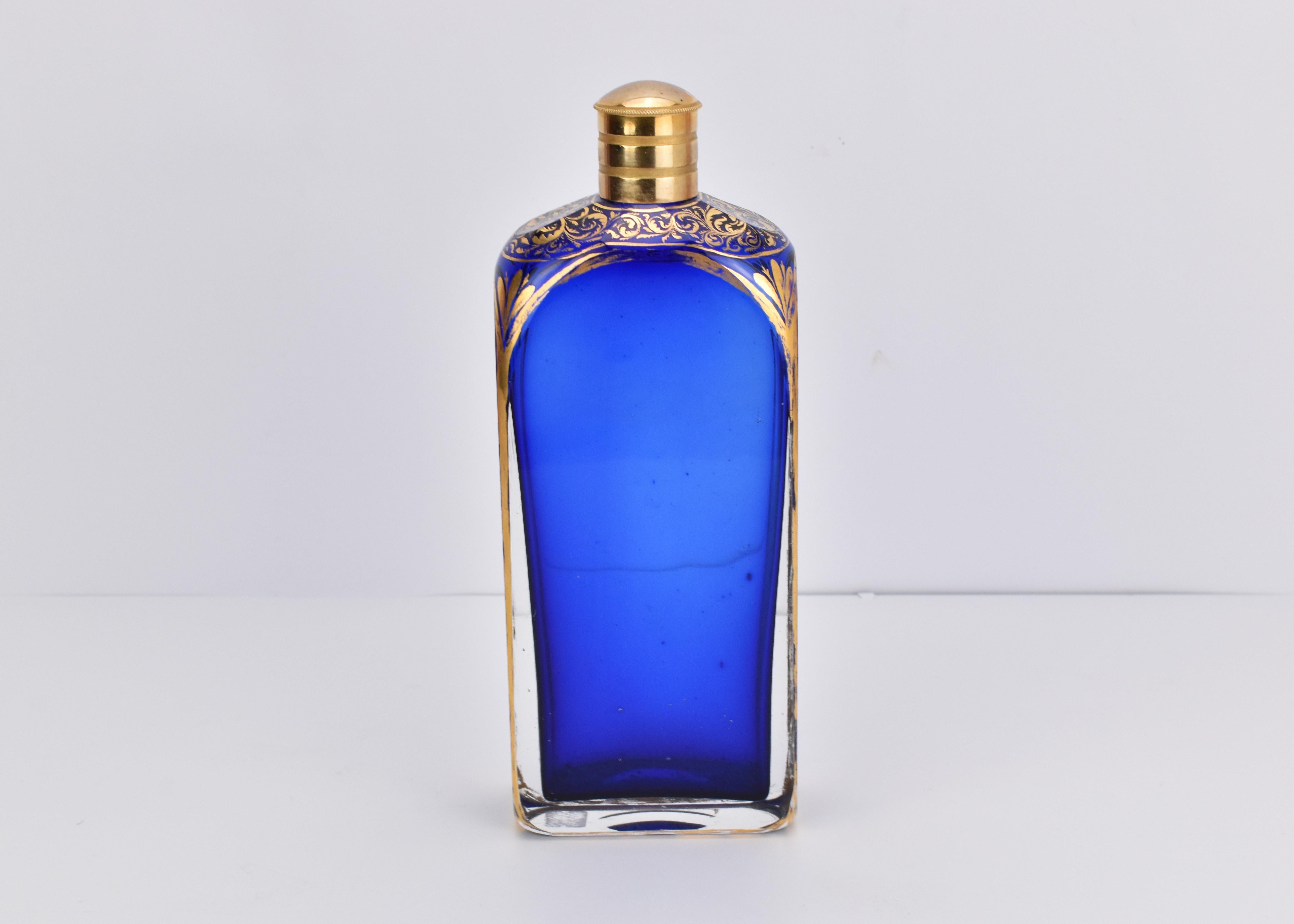 Antique perfume bottle with metal lid and glass stopper in cobalt blue crystal glass

rectangular body with gilded borders and hand-painted gilding decorations on top of the bottle

small cobalt blue glass stopper, covered with gilded metal