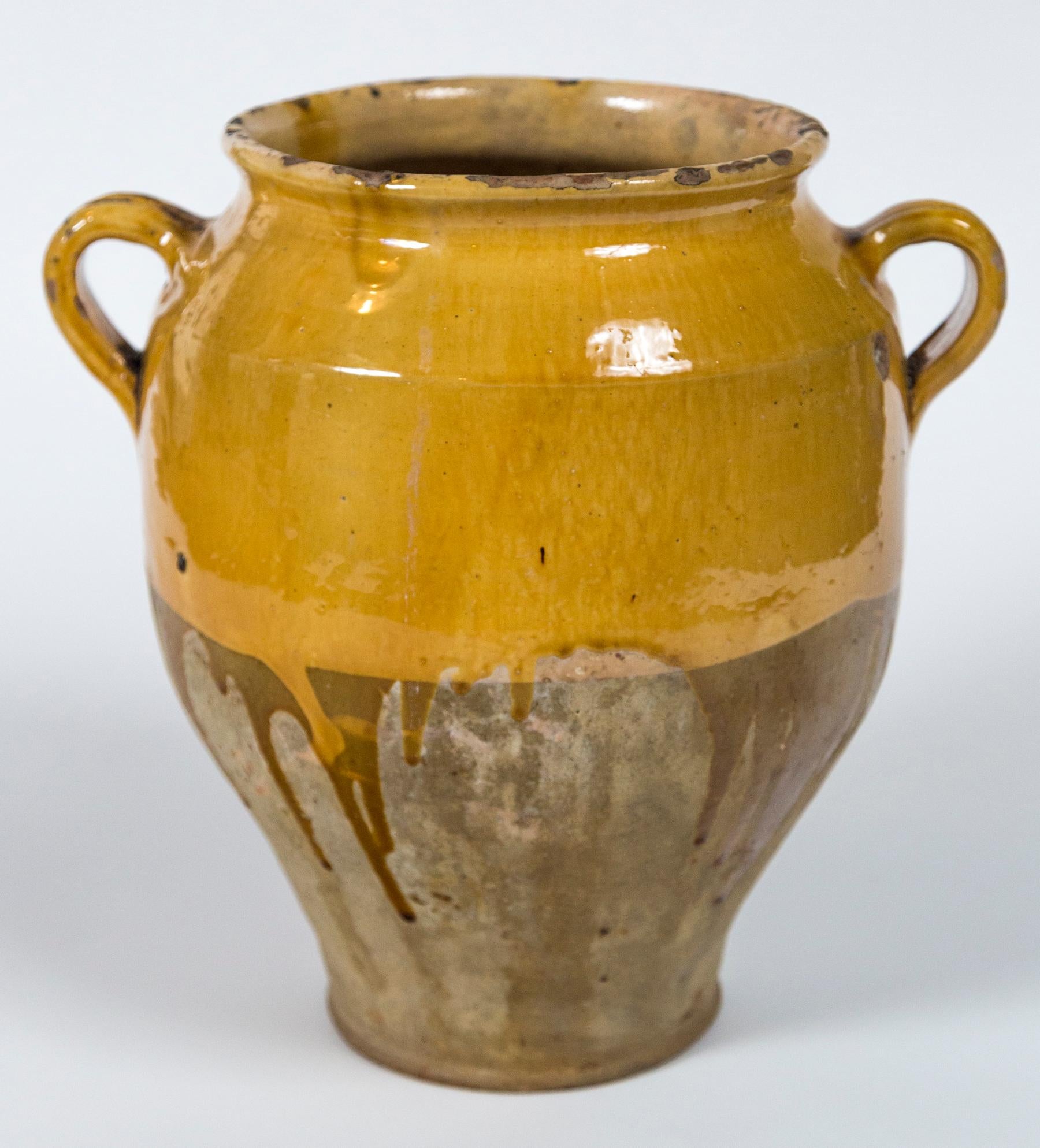 Antique French confit pot, circa 1900. Aged terracotta with deep yellow glaze. Confit pots were used for food preservation. The bottom half was left unglazed to allow the pot to keep cool while half buried in the ground.
