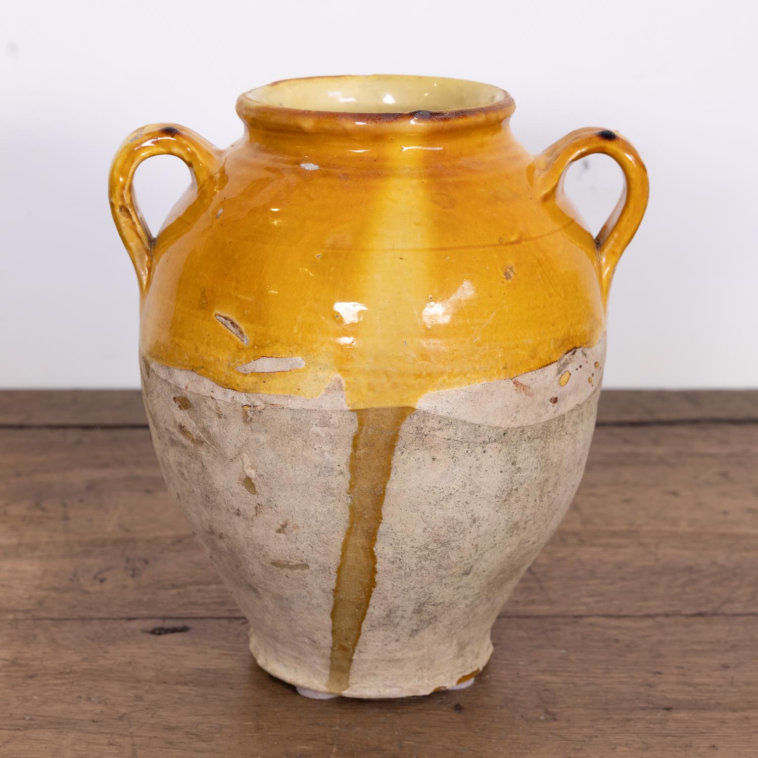 Antique French pot de confit or confit pot from southwest France having two handles and a luminous yellow glaze, circa 1880s. This utilitarian earthenware vessel was considered a staple in 19th century France, especially in kitchens found in the