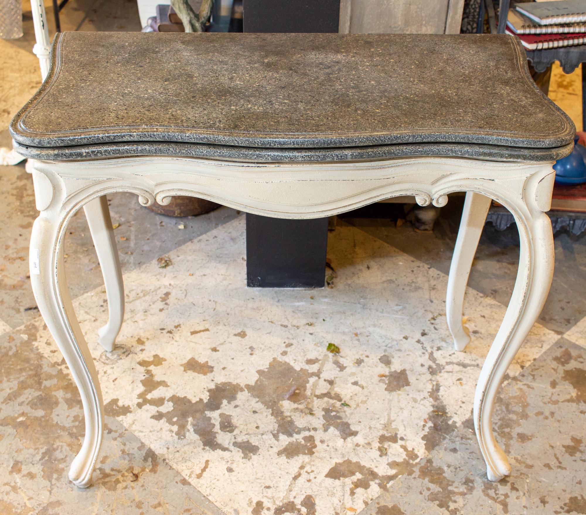 This antique French game table and console has a wonderful faux-painted finish. The top is finished in a faux stone with tones of gray, charcoal, greige and black. The table unfolds to reveal a black embossed leather top inside, perfect for the card